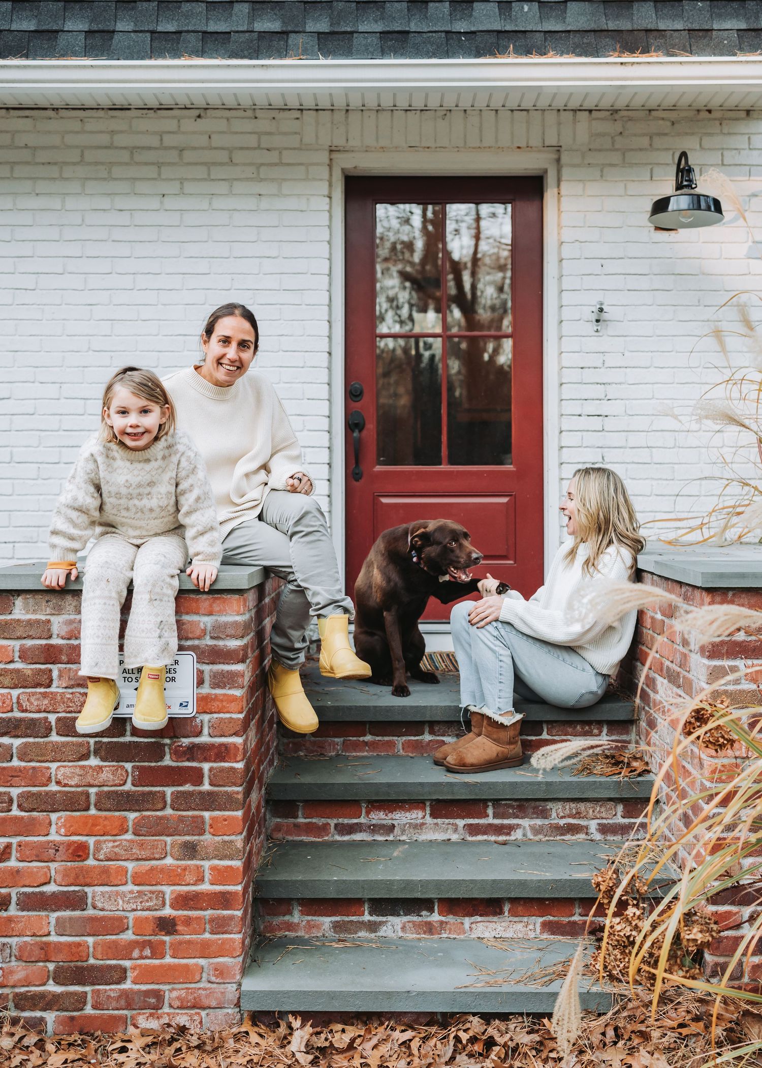 Lifestyle photos show people sitting on rustic brick house steps during a cozy winter photo session.