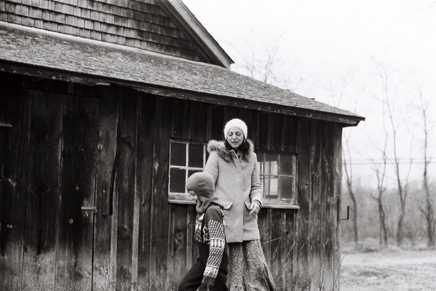 Sequential black and white photos of a mysterious figure emerging from a dark wooden cabin in foggy weather.