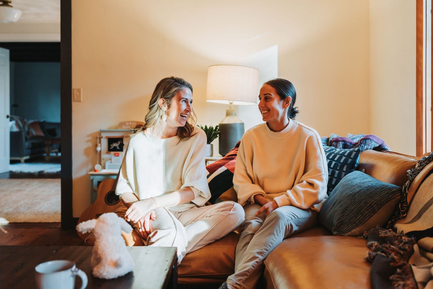 Group of friends spending time together at home while watching television and having drinks.