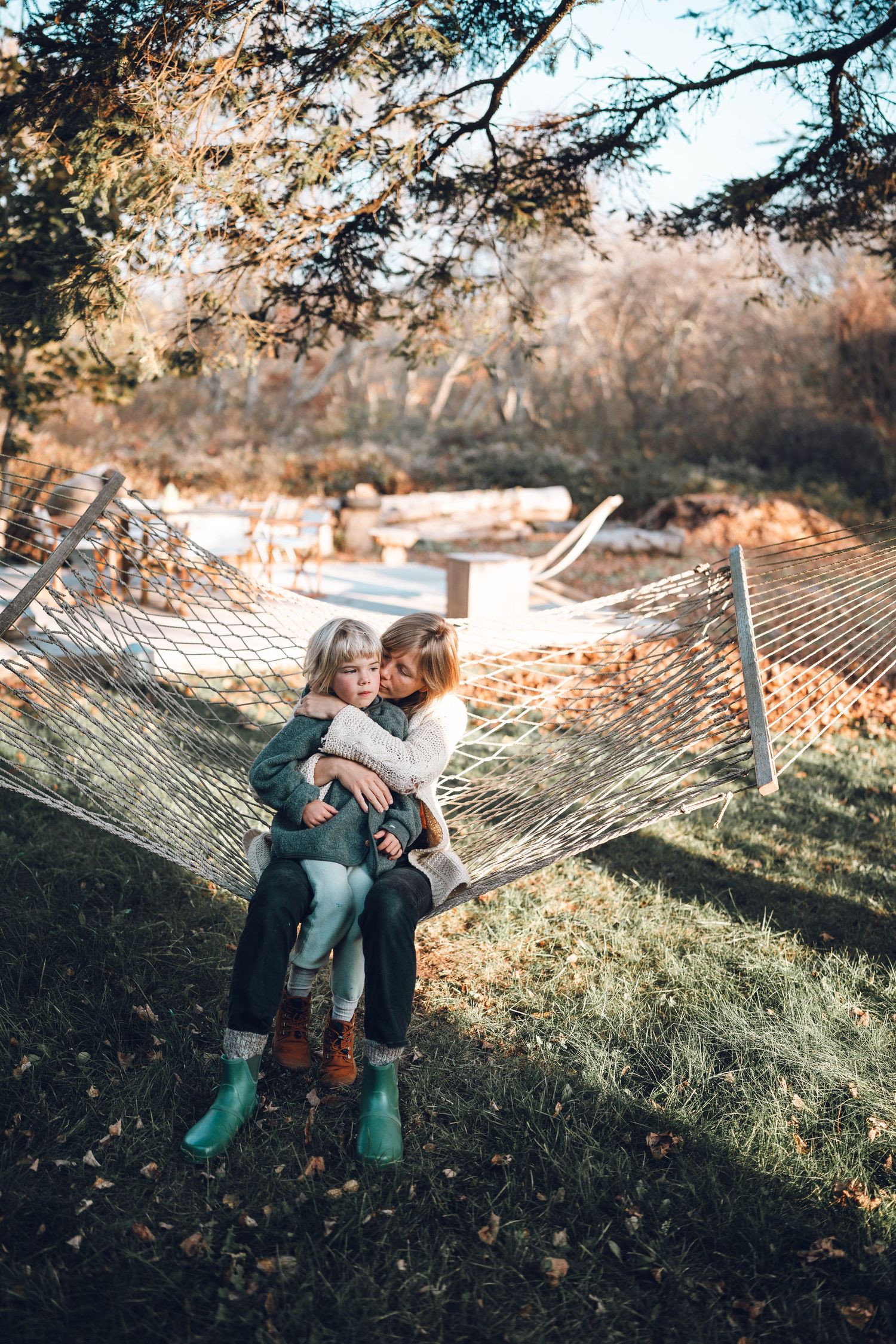 Cozy afternoon cuddles in a backyard hammock during golden hour.