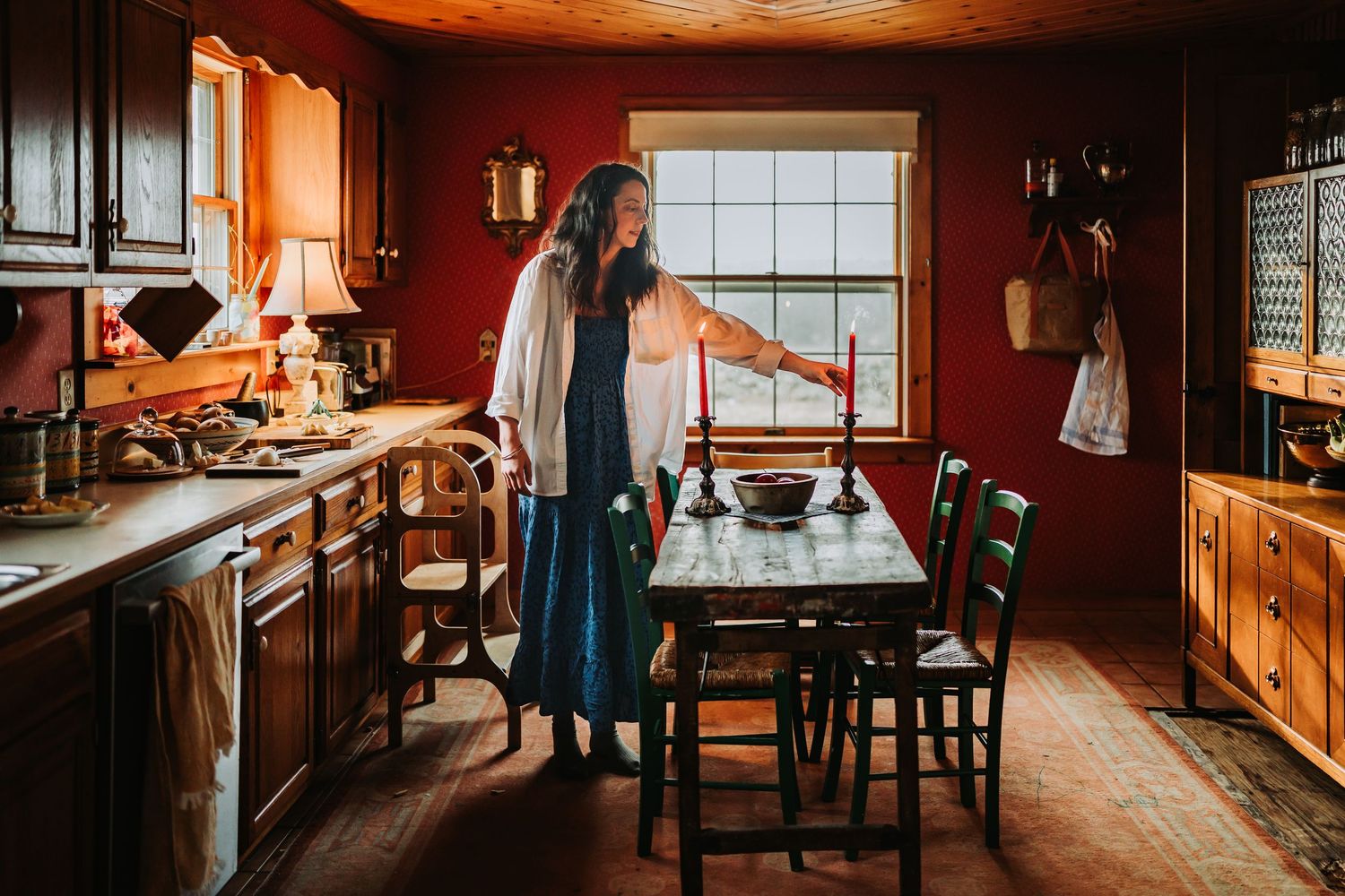 Warm sunlight streams through windows into a cozy rustic kitchen with wooden cabinets and vintage decor.