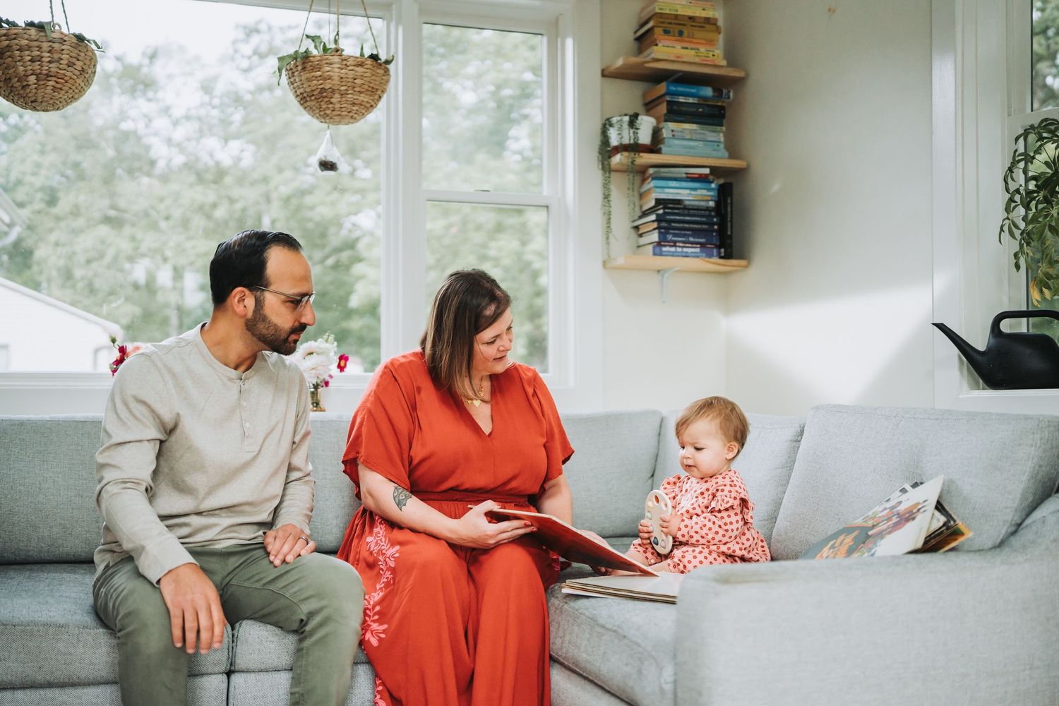 A series of candid family moments in a bright living room shows parents and baby relaxing together on a white couch.