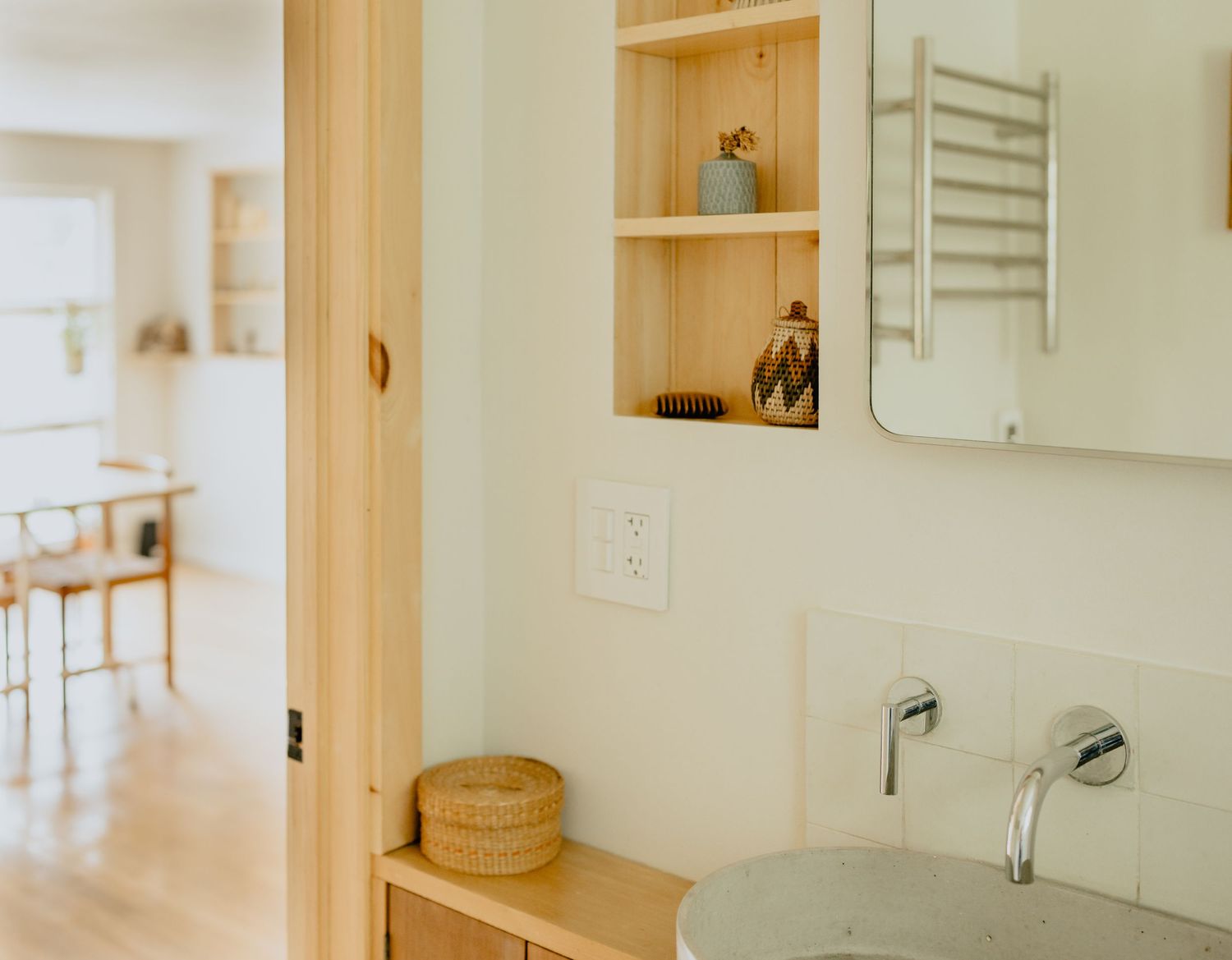 Bright and minimalist hallway featuring white walls, warm wood accents, and built-in storage solutions in a modern home.