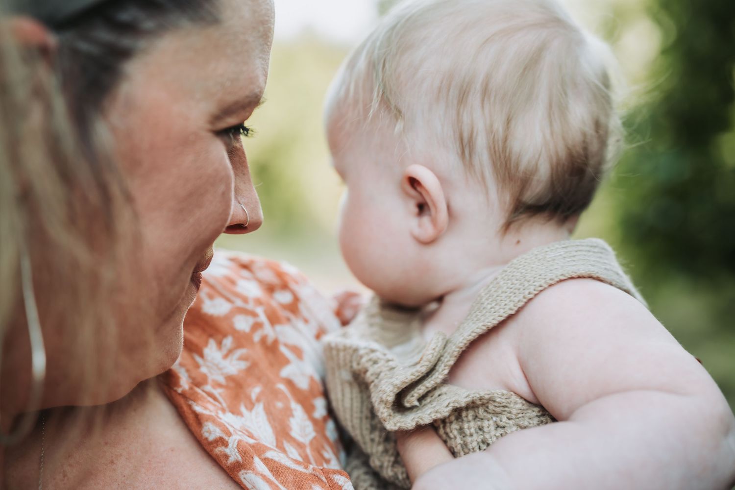Close up moments of gentle interaction between adults and child in outdoor setting.