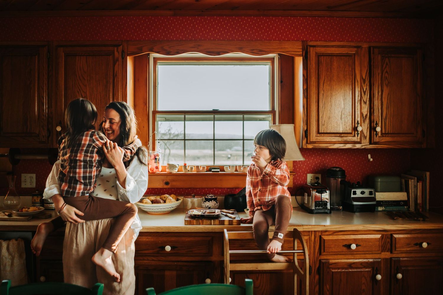 A couple preparing food together in a rustic kitchen with warm lighting and wooden cabinetry.