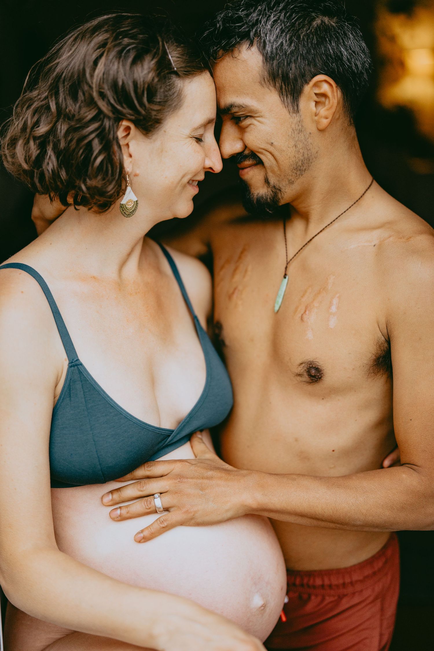 An intimate maternity photo of an expecting couple sharing a tender moment.