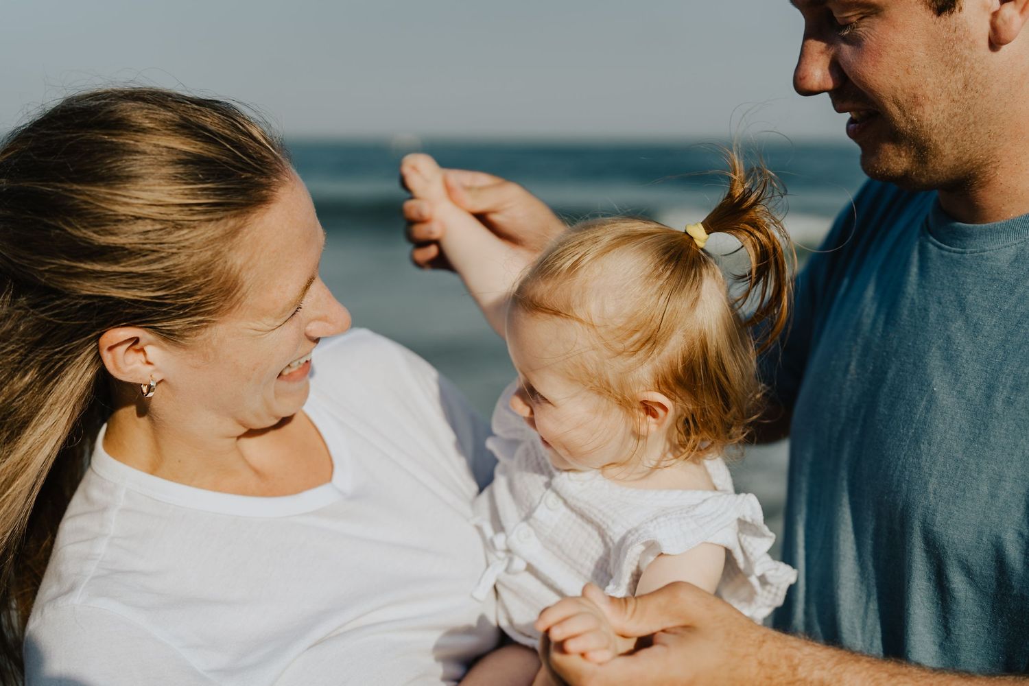 Sweet family moment captured at beach during sunset.