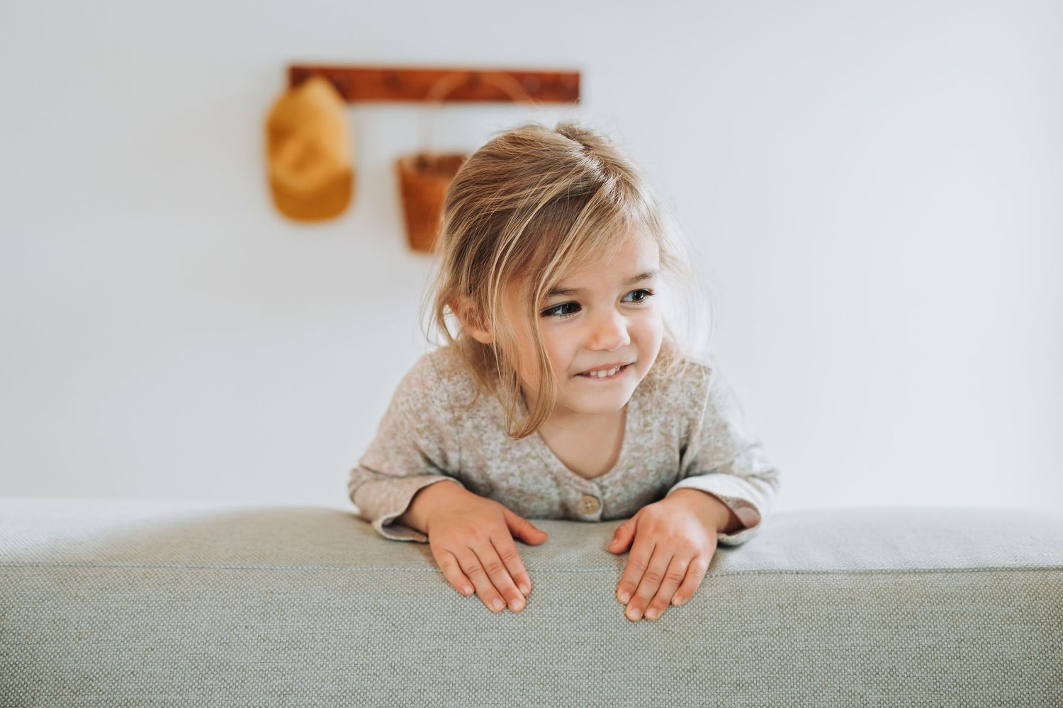 A child is laying on their stomach on a light colored floor, viewed from multiple angles in a collage format.