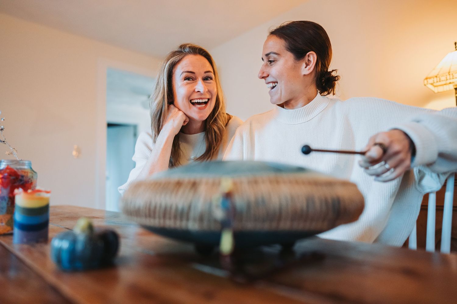 Mother and daughter sharing laughs while baking together in a bright kitchen.