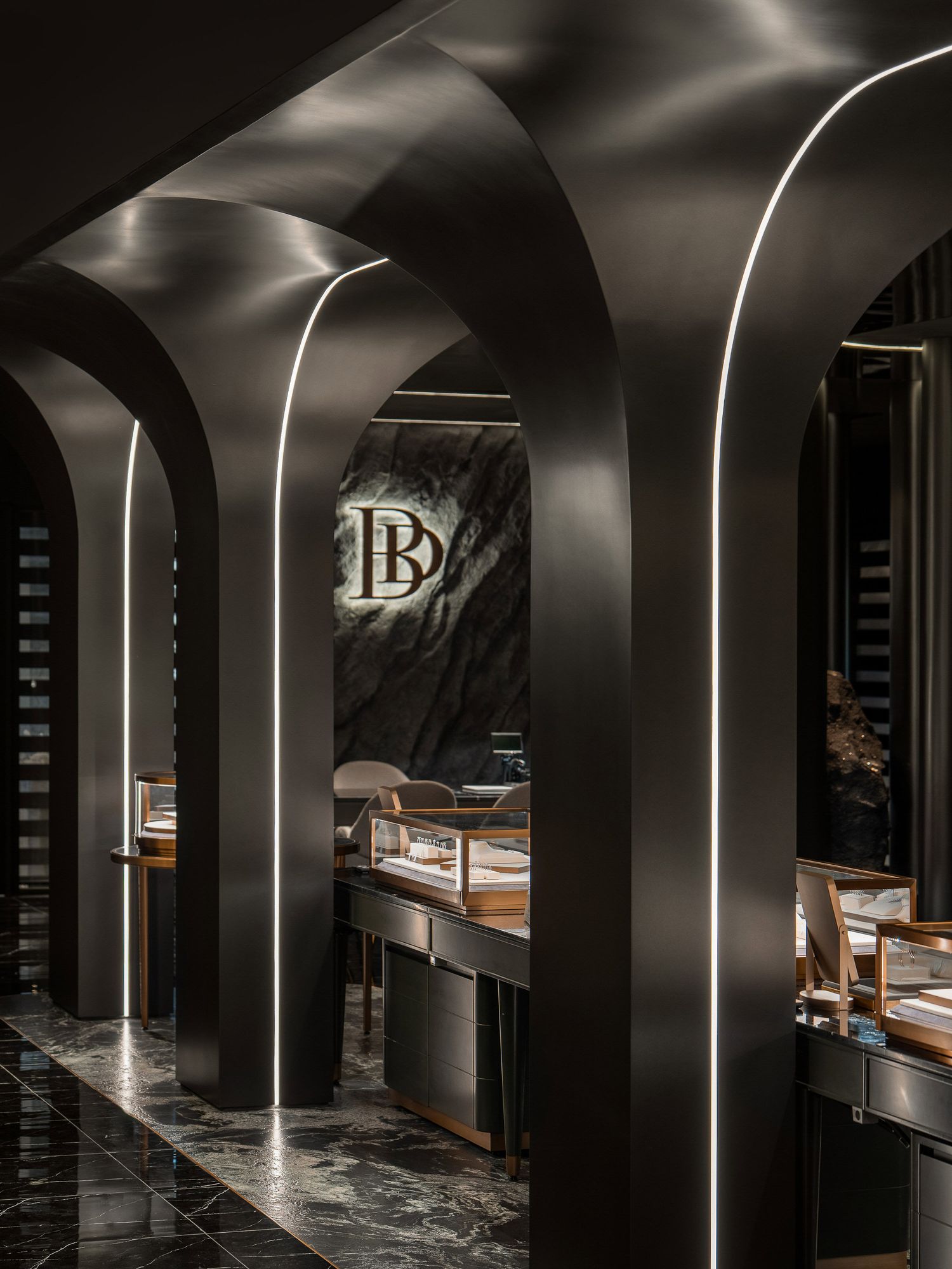 Modern interior design with curved black walls illuminated by elegant vertical LED lighting strips creating dramatic shadows.