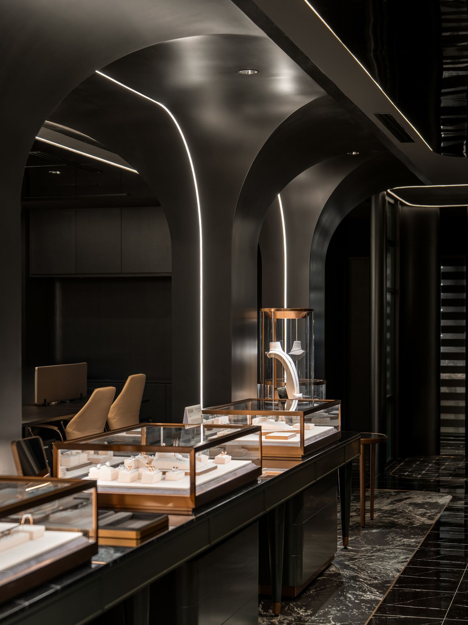 Modern spa interior with curved walls features illuminated display cases and wooden benches in a dimly lit atmosphere.