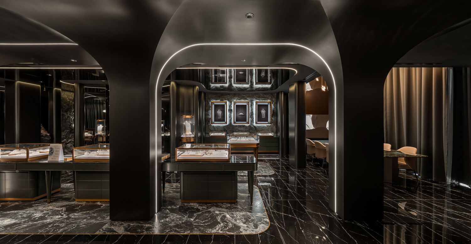Luxurious modern restaurant interior with arched doorway, dark marble floors and moody ambient lighting.