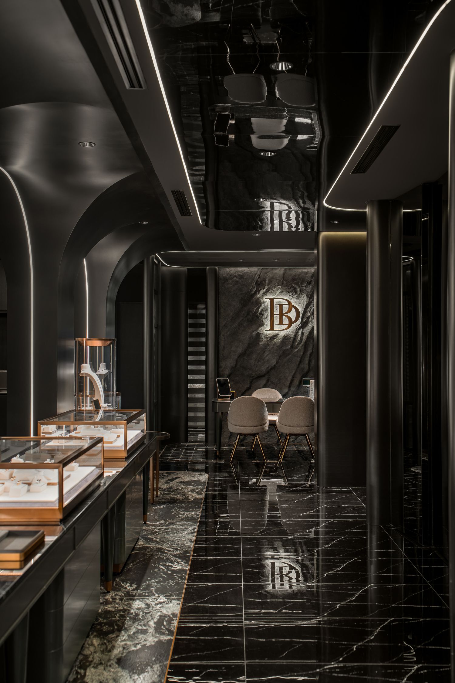 Modern luxury spa interior with dark marble floors, sleek black walls, and illuminated display cases creating a dramatic atmosphere.