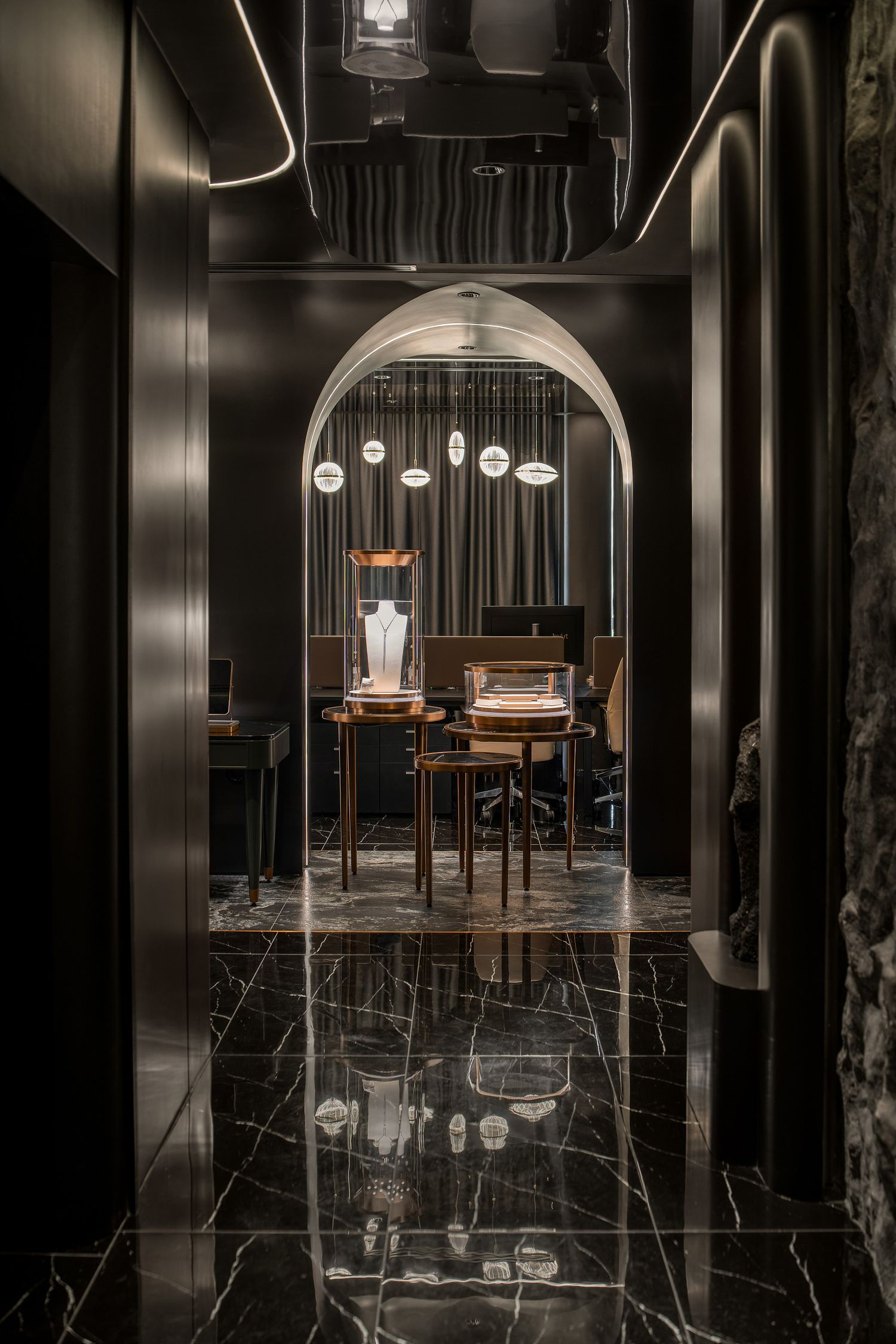 Modern dark restaurant interior with wooden tables and hanging pendant lights reflecting on glossy black floor.