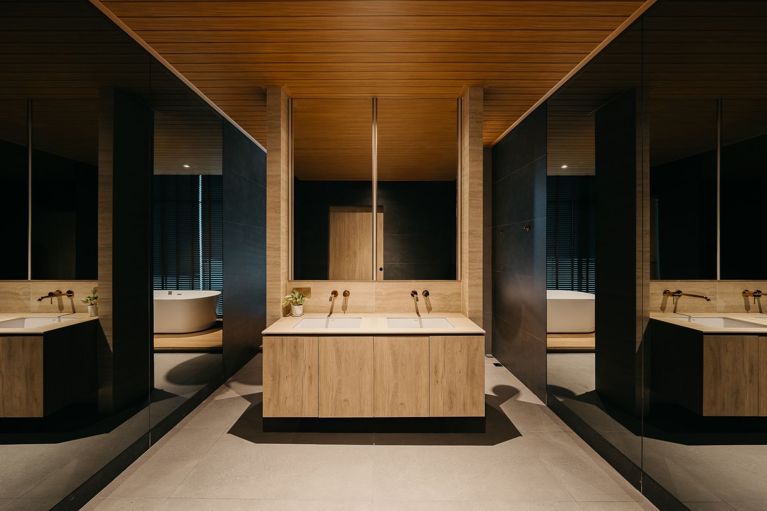 Modern luxury bathroom with wooden walls, floating vanity, and minimalist fixtures illuminated by soft lighting.