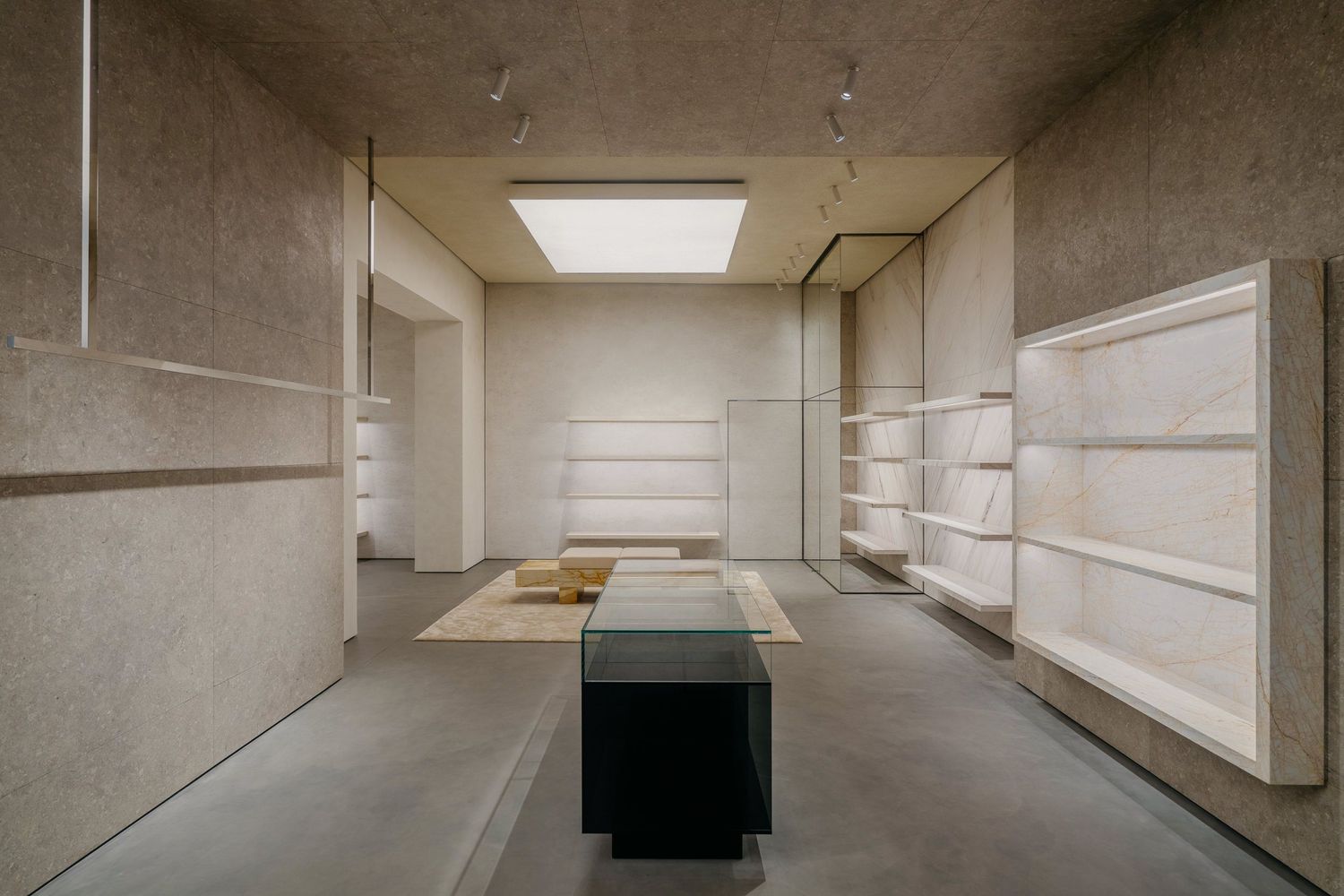 Contemporary retail space featuring white display shelves, black center island, and recessed lighting.