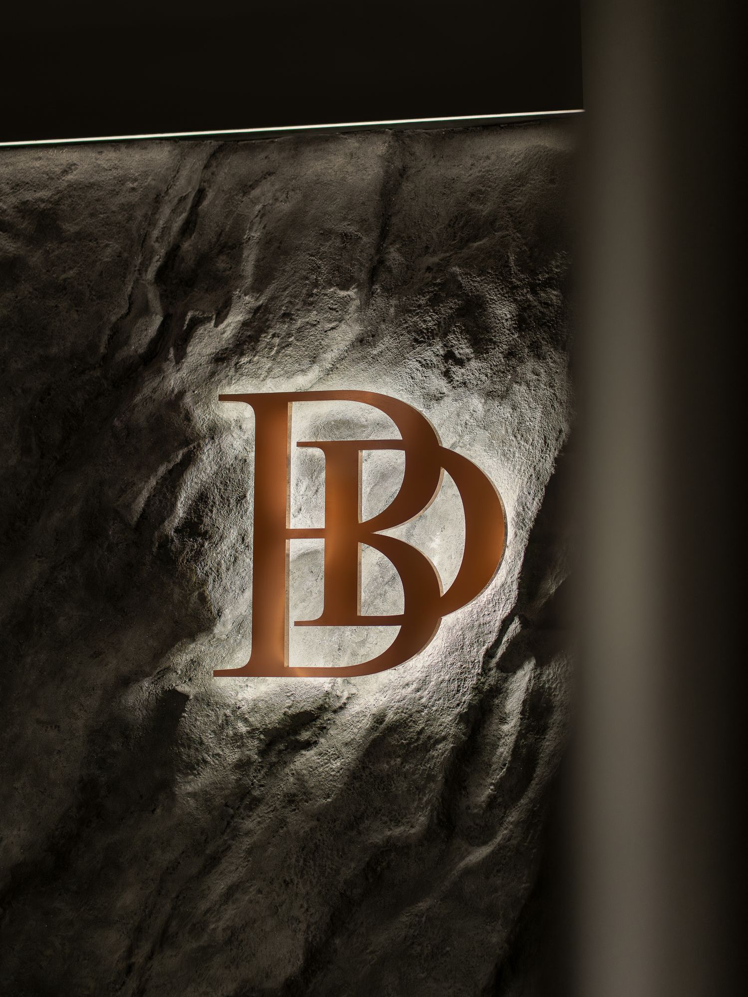 Dark abstract sequence showing letters 'D' appearing progressively in a textured shadowy environment.