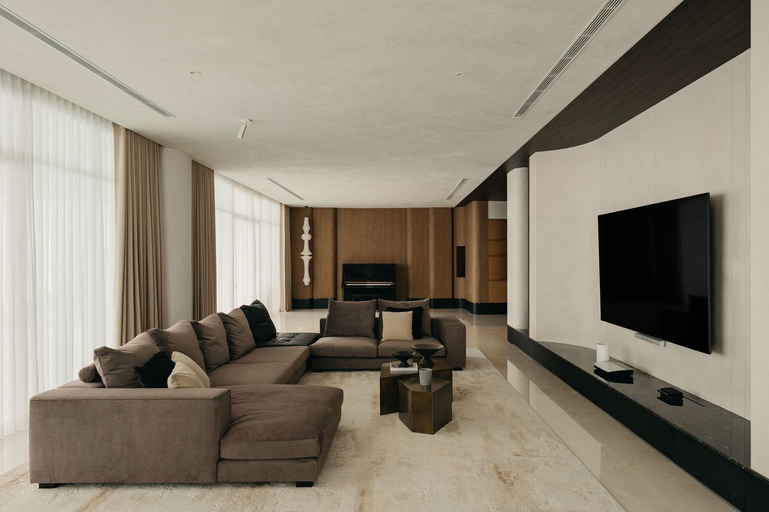 Modern minimalist living room interior with grey sectional sofa and white walls in open concept design.