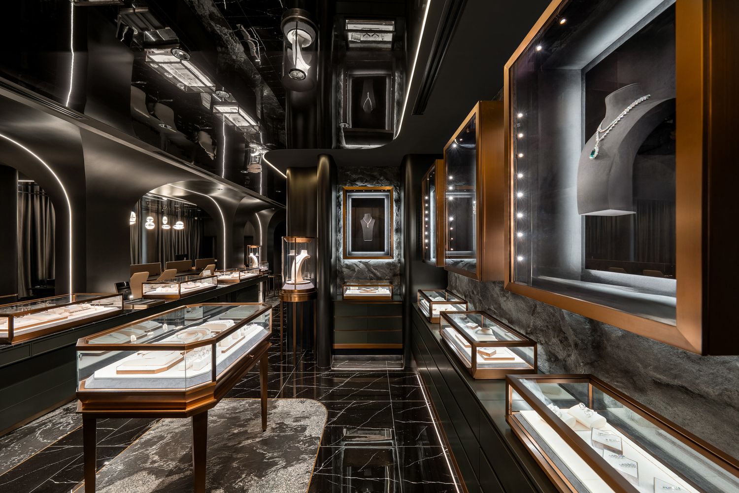 A dimly lit modern restaurant interior with sleek black walls, pendant lighting, and contemporary dining furniture.