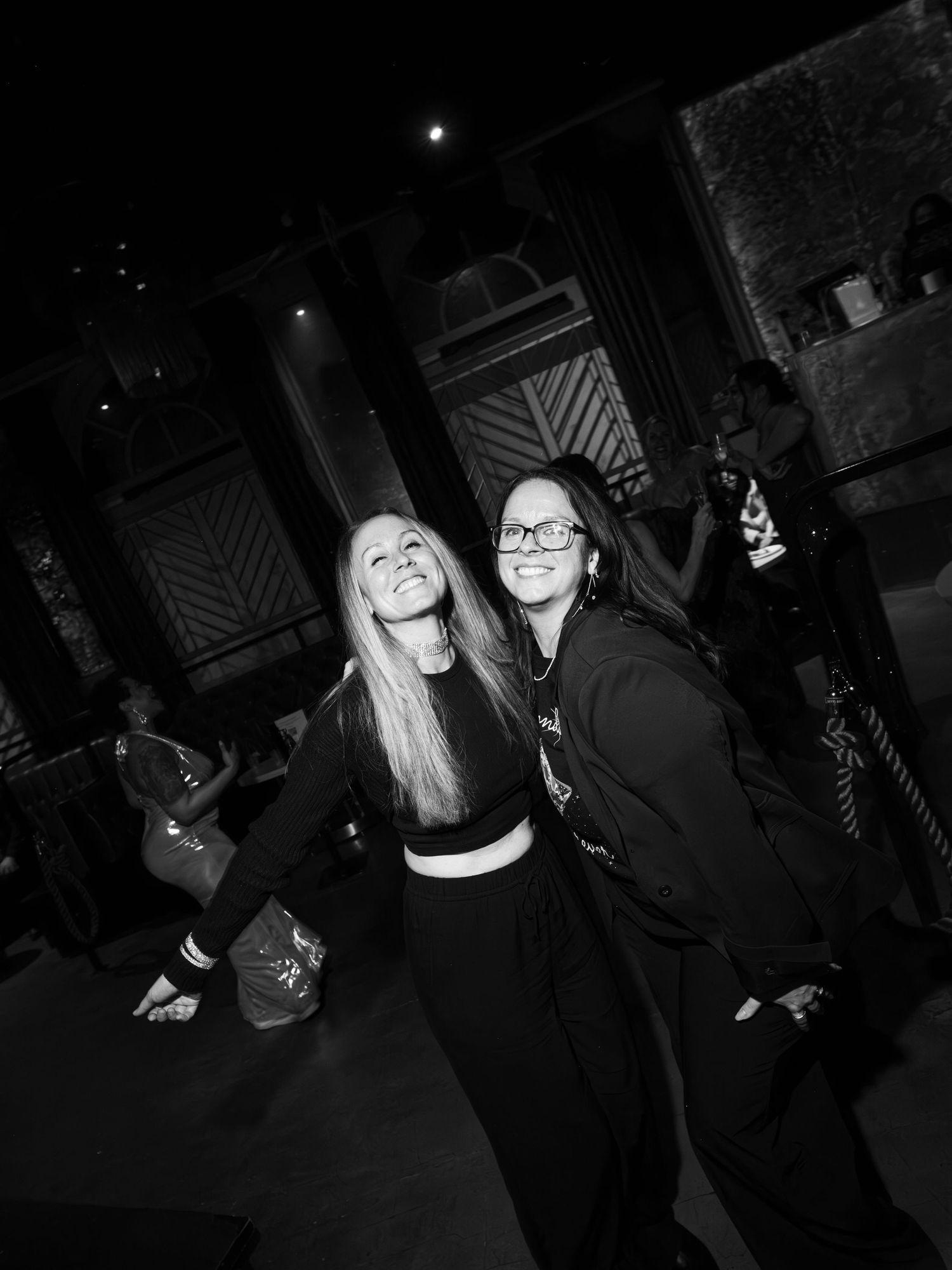 A group of people enjoying themselves at a dark nightclub or party venue, captured in a series of black and white photos.