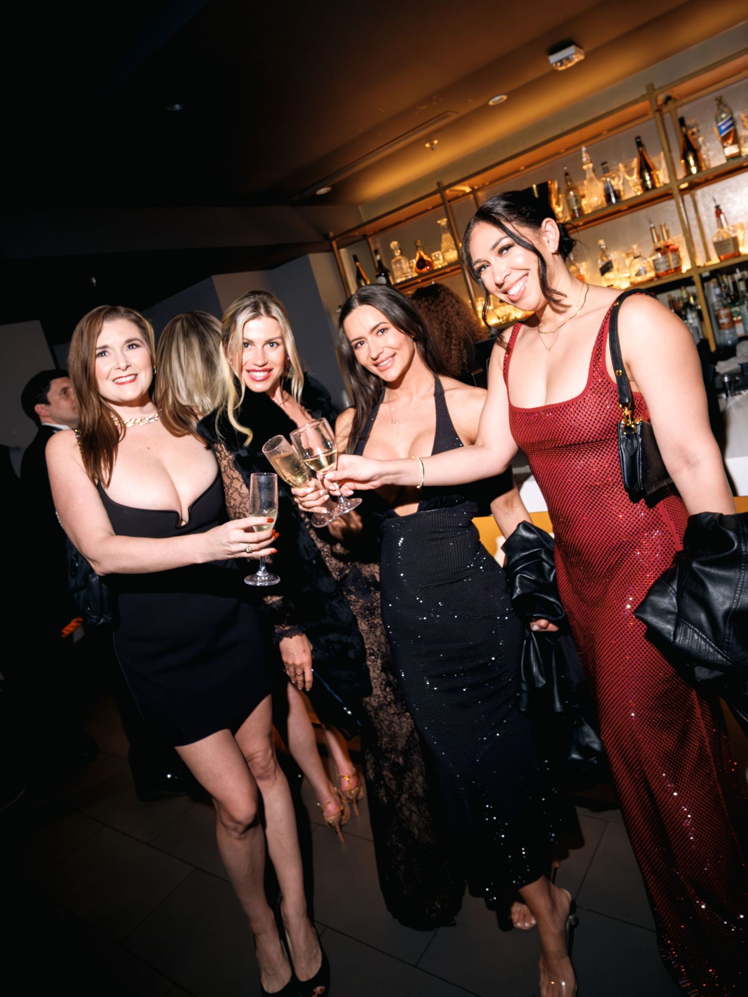 Group of friends enjoying a lively night out at a dimly lit bar or club venue.