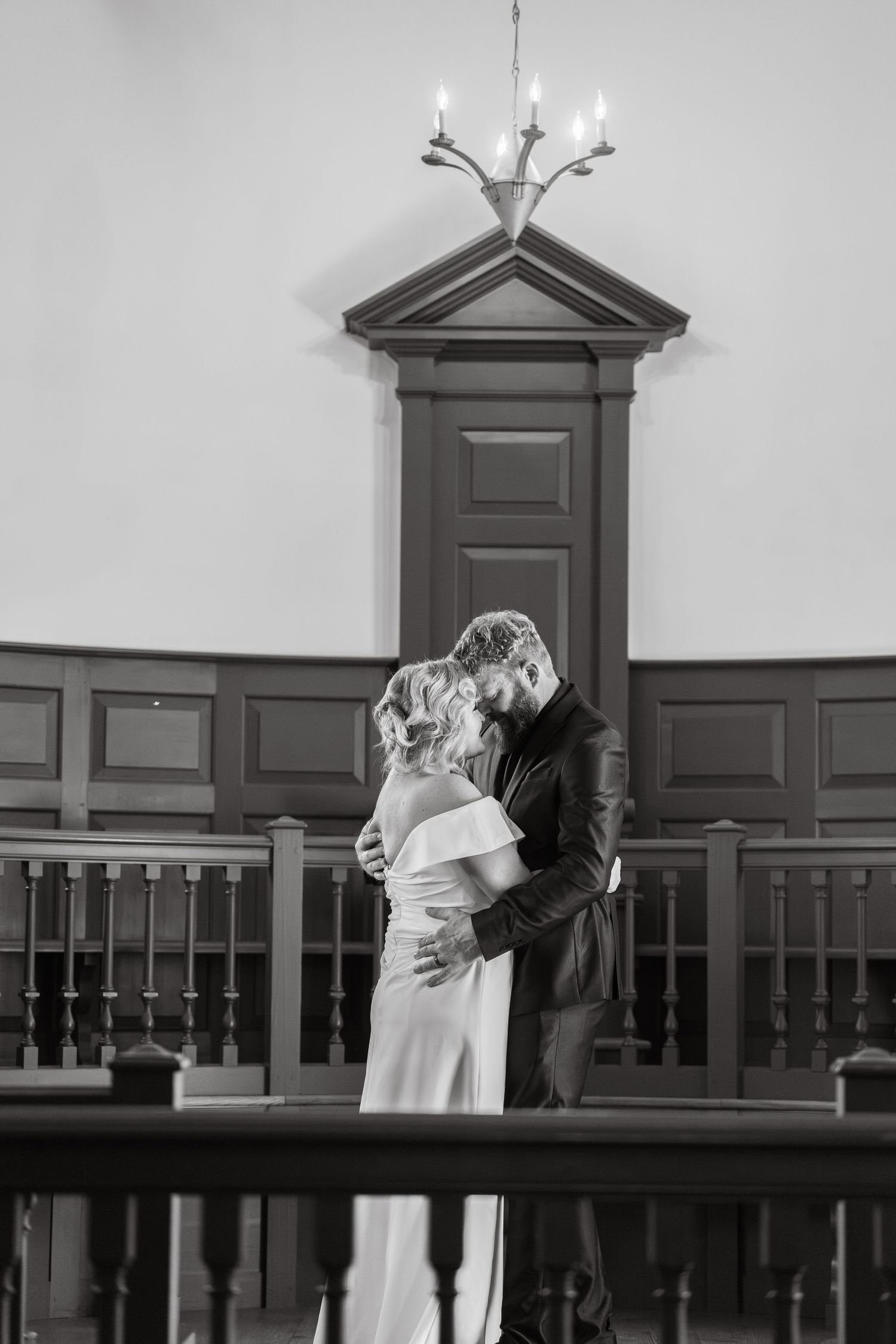 A sequence of four black and white photographs showing a couple embracing and kissing against a church interior.