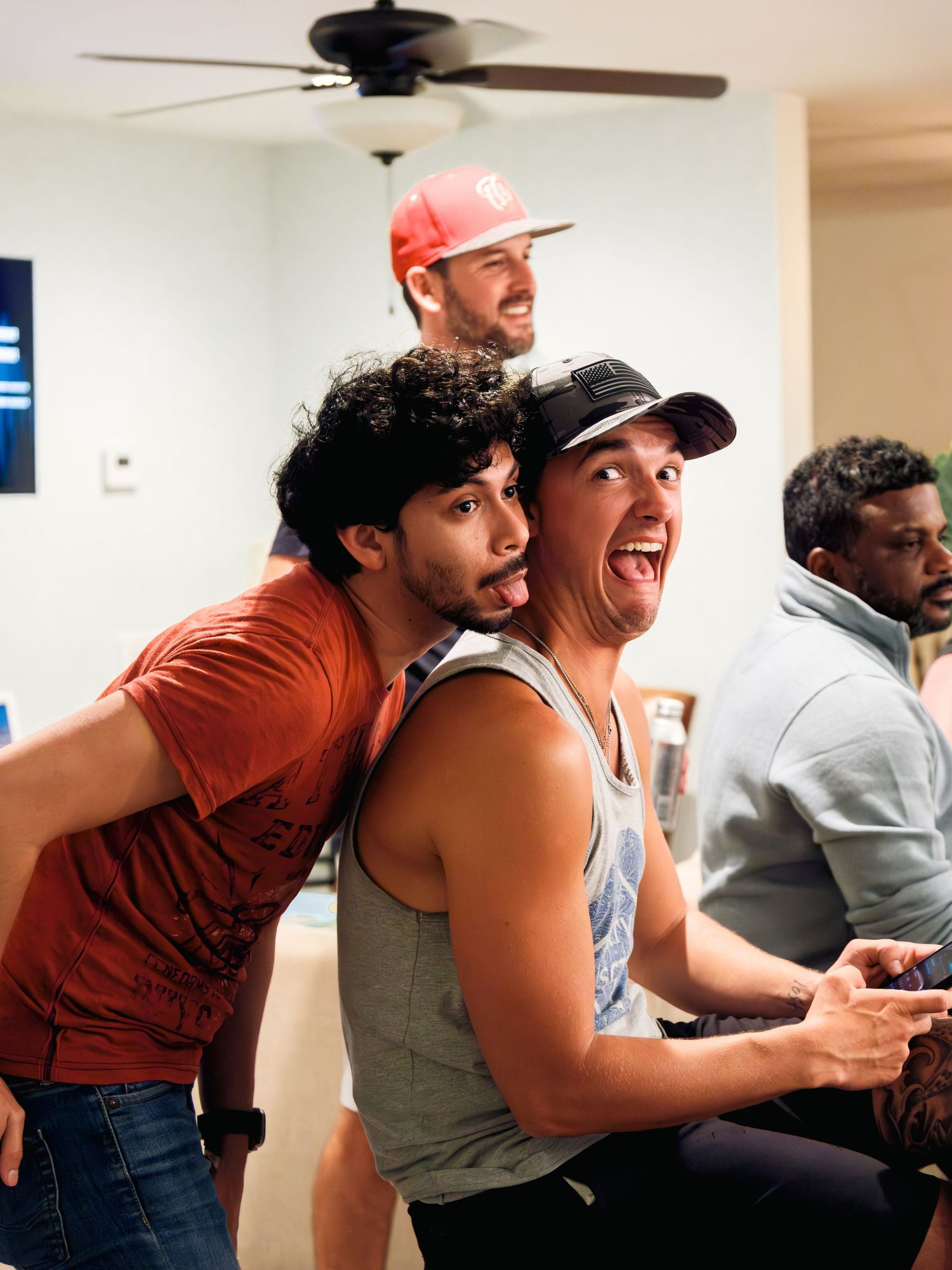 A group of people lean in close together while reacting excitedly to something offscreen.