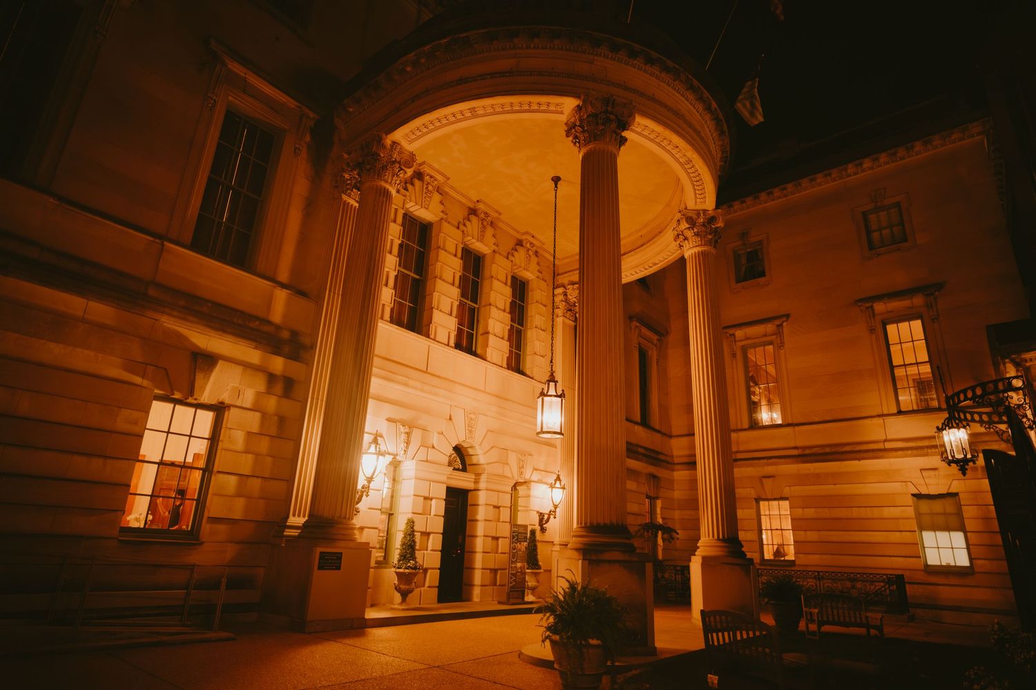 Illuminated historic building interior with ornate architectural details and warm lighting creating an elegant ambiance at night.