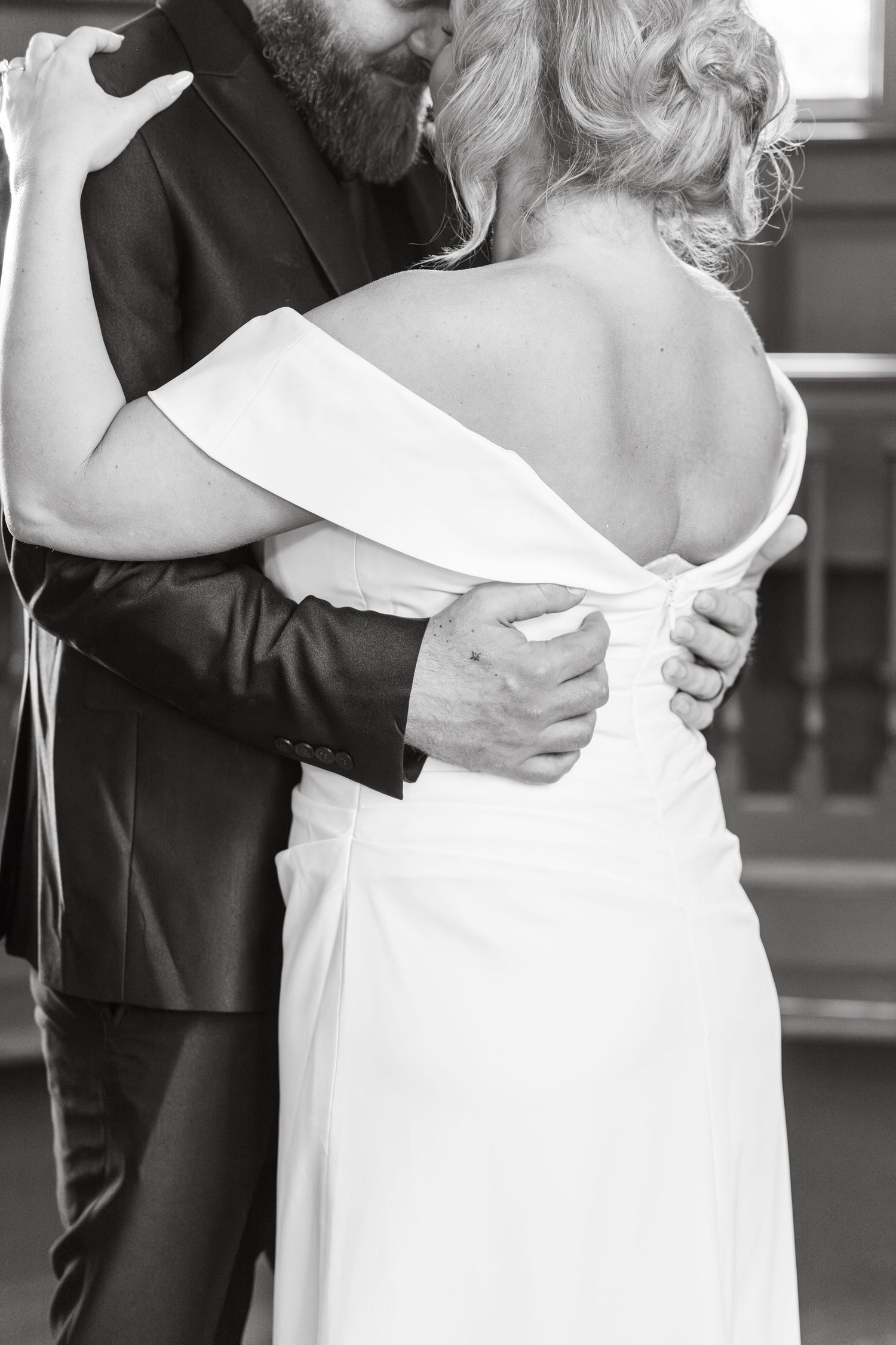 Black and white photo series showing intimate close-up details of a couple embracing during a wedding ceremony.