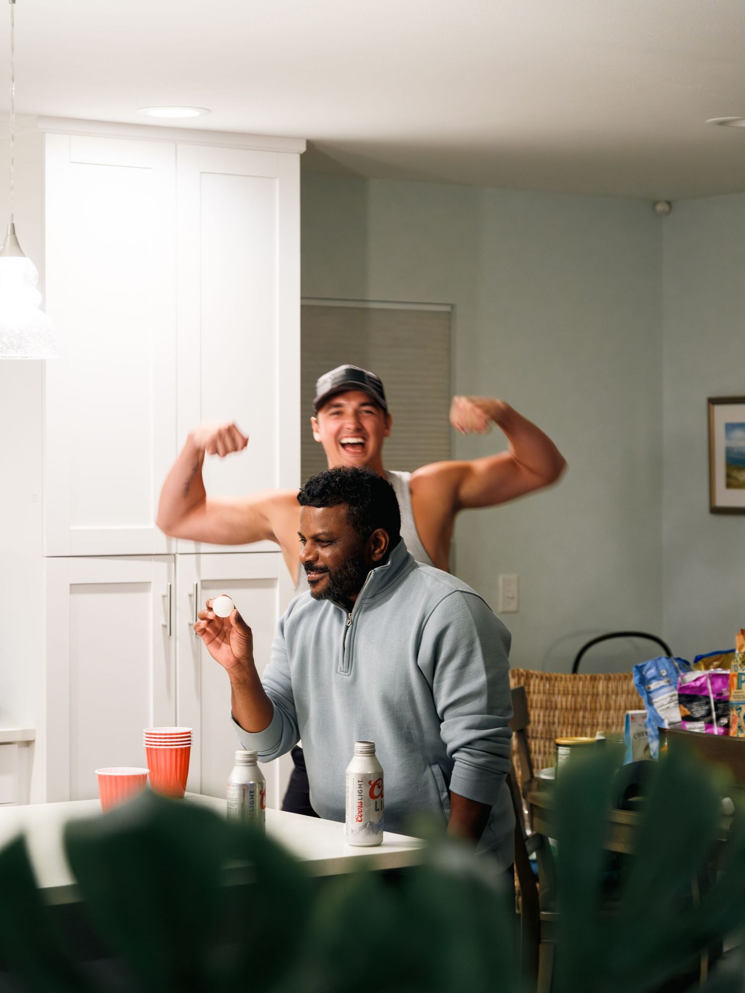 A person in a gray sweatshirt performs three different celebratory poses in a sequence of candid indoor shots.