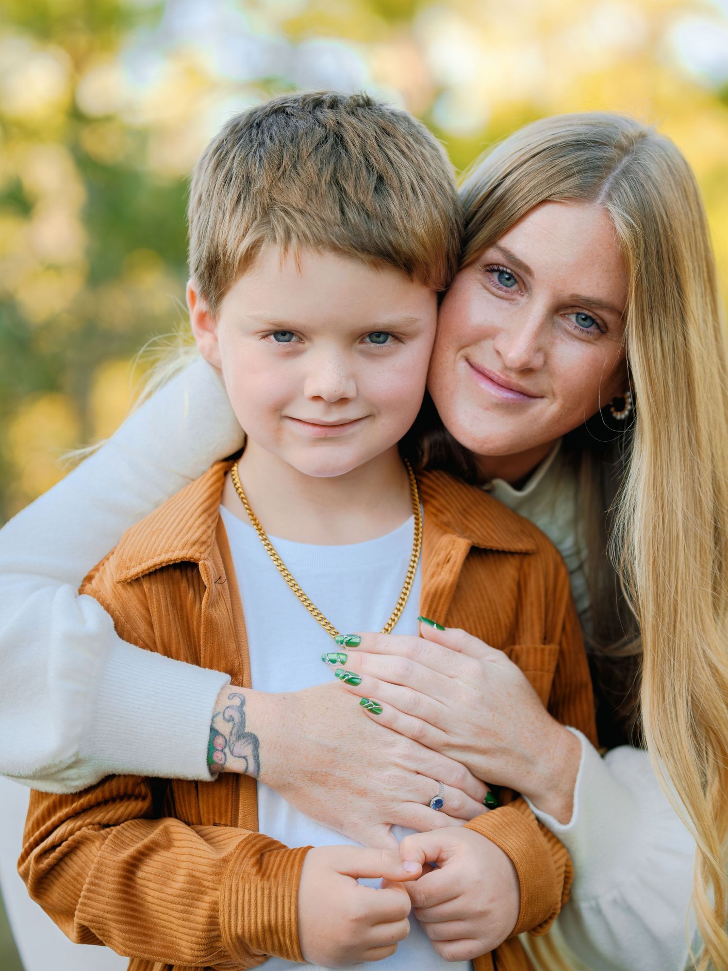 A loving autumn portrait session featuring warm embraces and coordinated brown and cream outfits in golden sunlight.