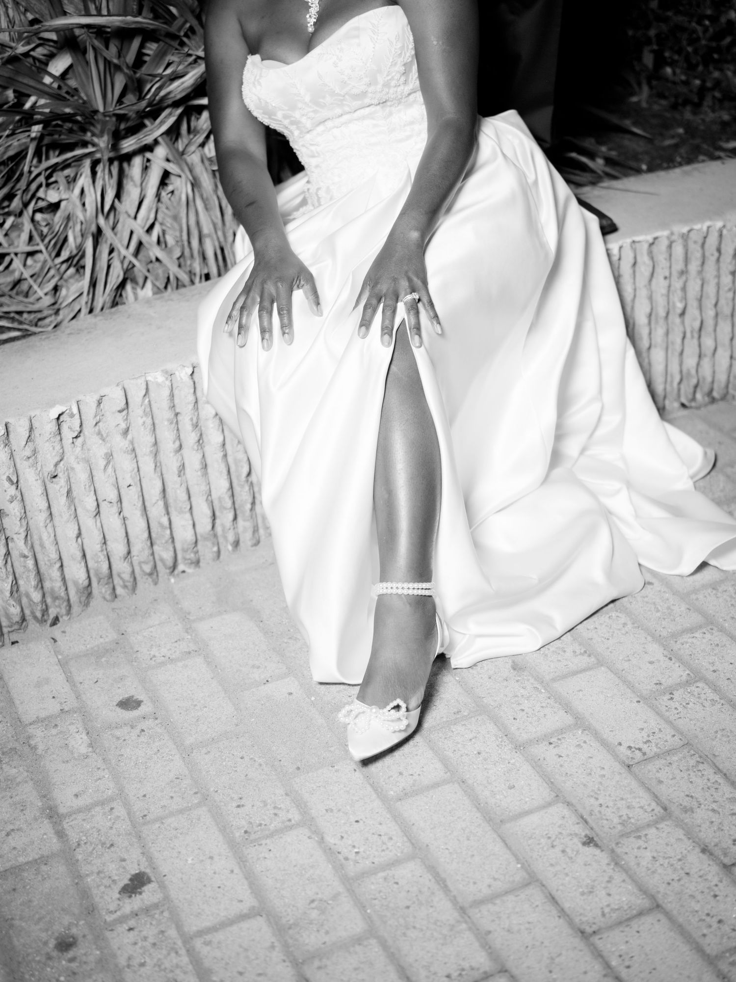 Black and white detail shots of a bride's white wedding dress and shoes.