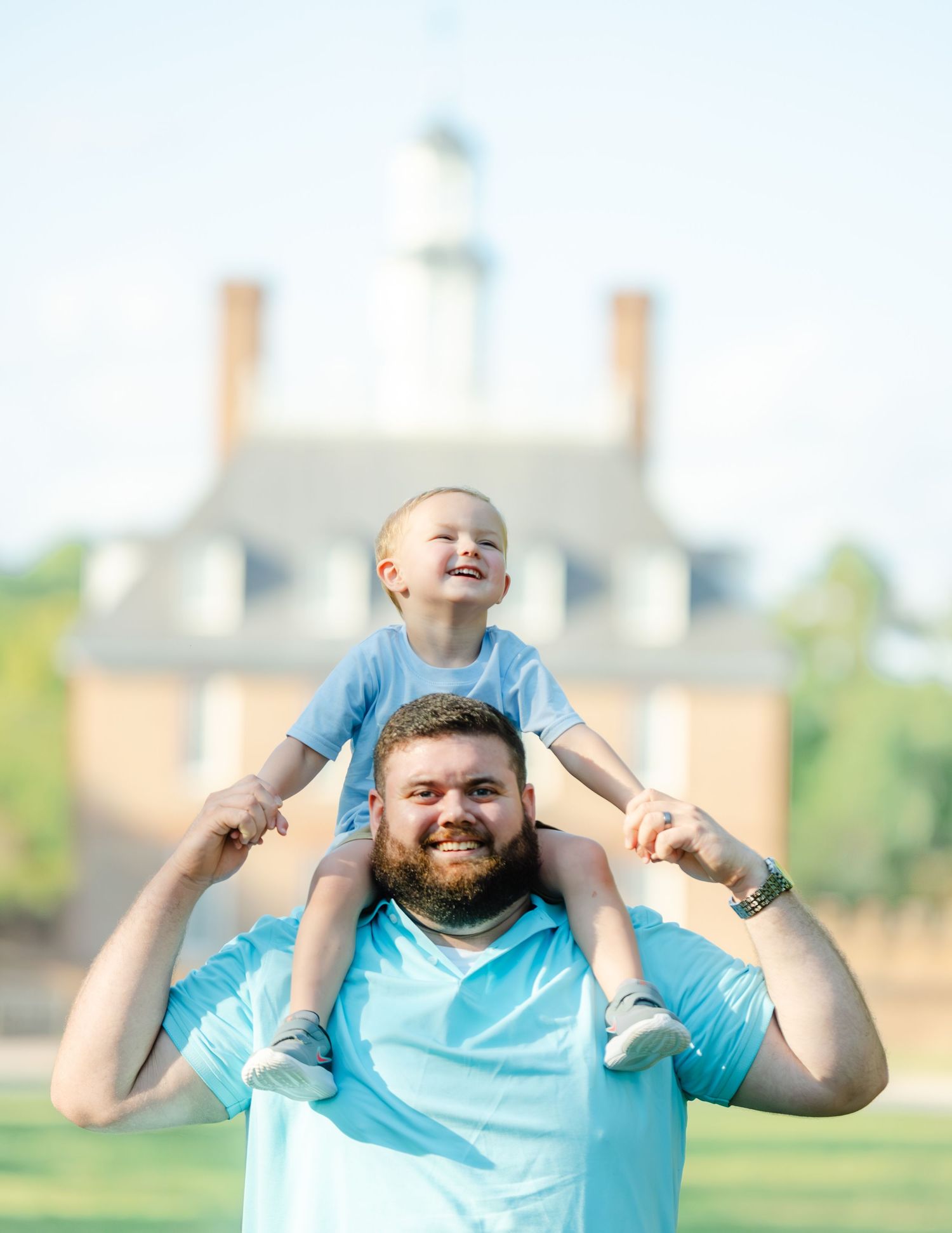 A joyful moment shared between two family members playing together outdoors on a sunny day.