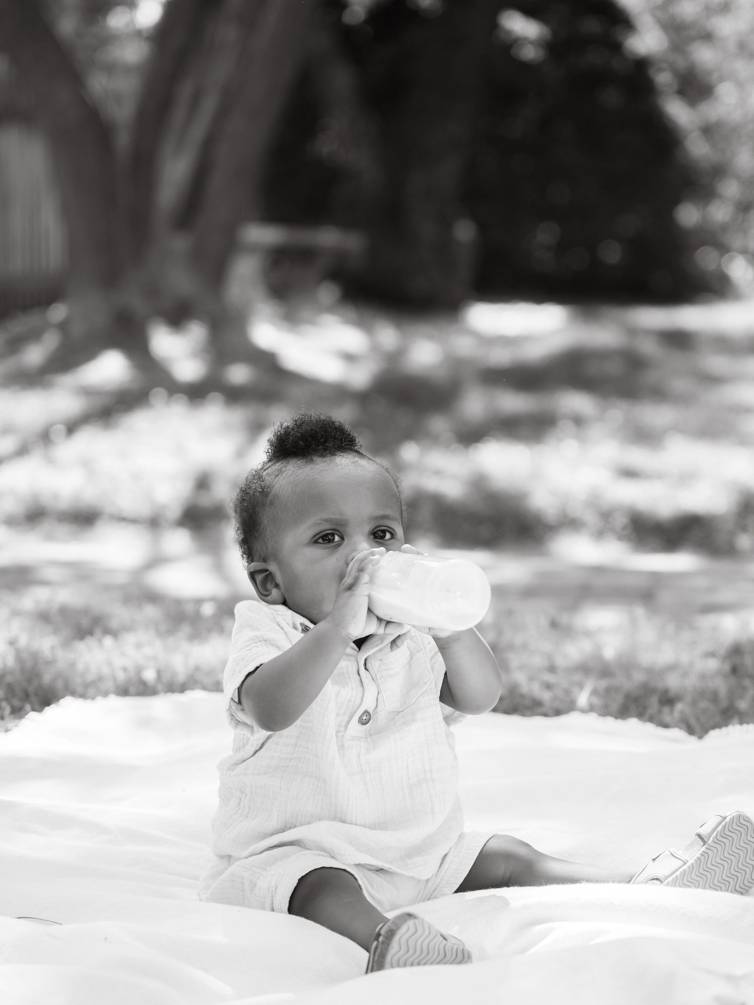 A series of grayscale photos showing a young baby lying down while making adorable facial expressions.