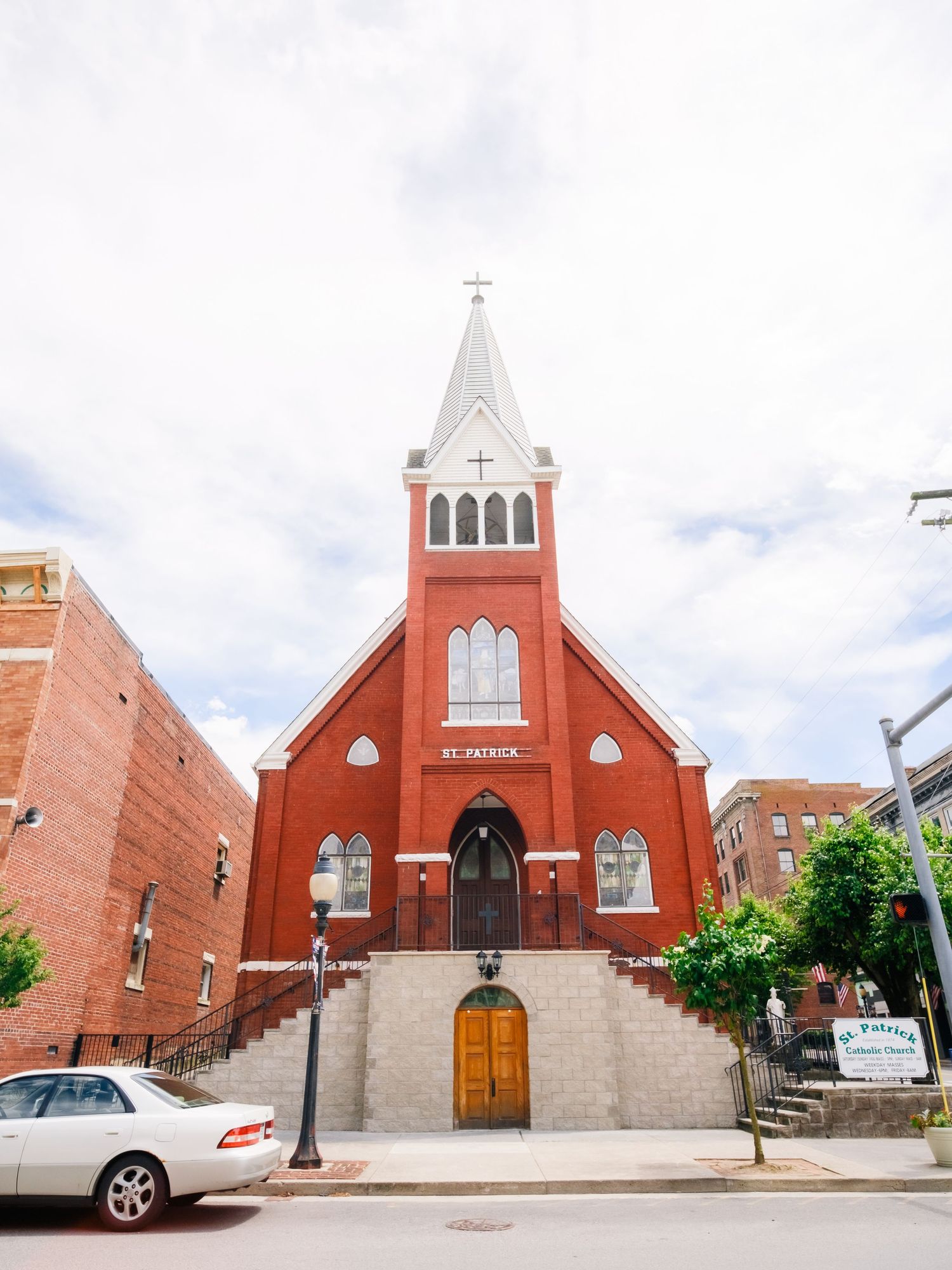Red brick church buildings with white accents and steeples stand in a row showing different architectural perspectives.