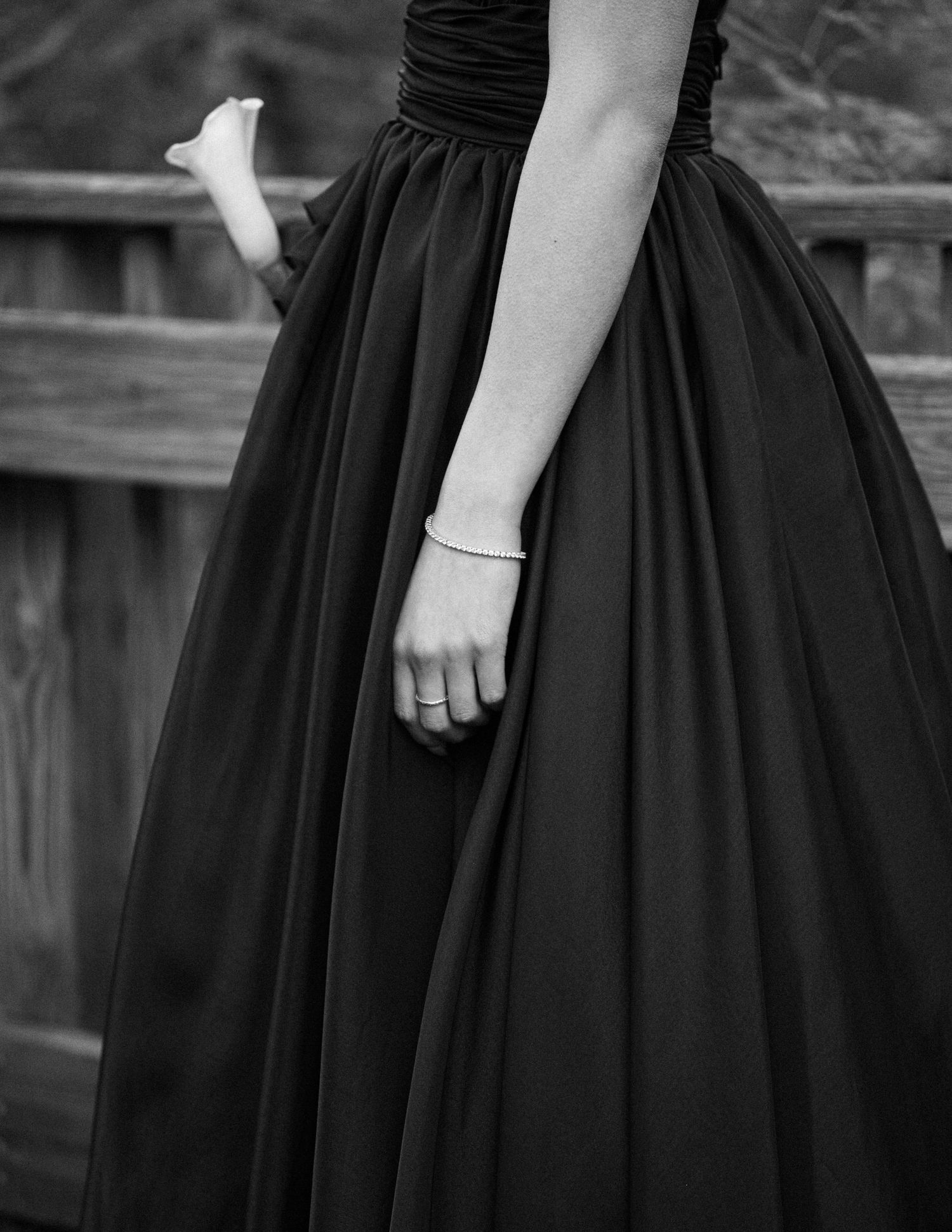 Black and white photo showing closeup details of a vintage-style pleated dress with delicate gathering at the waist.