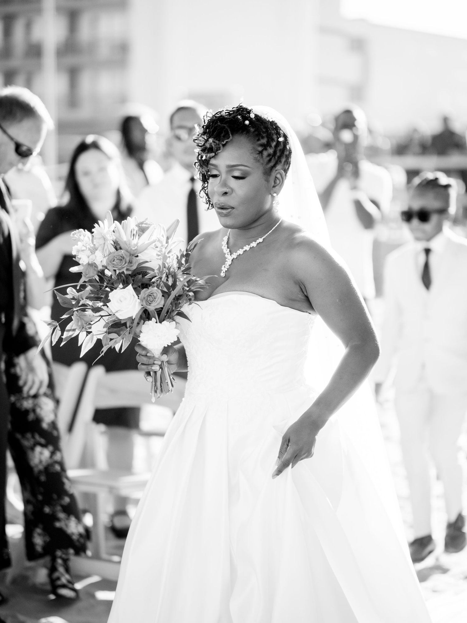 Black and white wedding photographs showing bride with bouquet and flowing dress details.