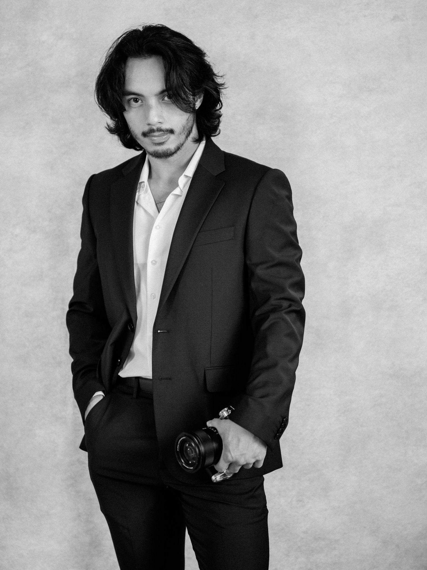 Black and white portrait series showing a figure in a dark suit and white shirt against a light background.