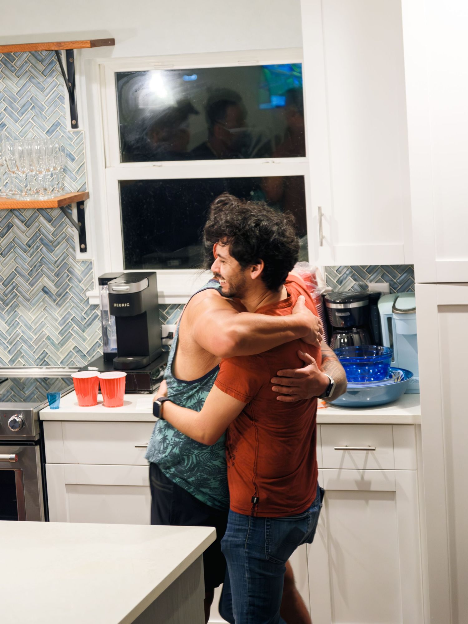 Sequence of three photos showing a playful hug and spin between two people in a modern kitchen interior.