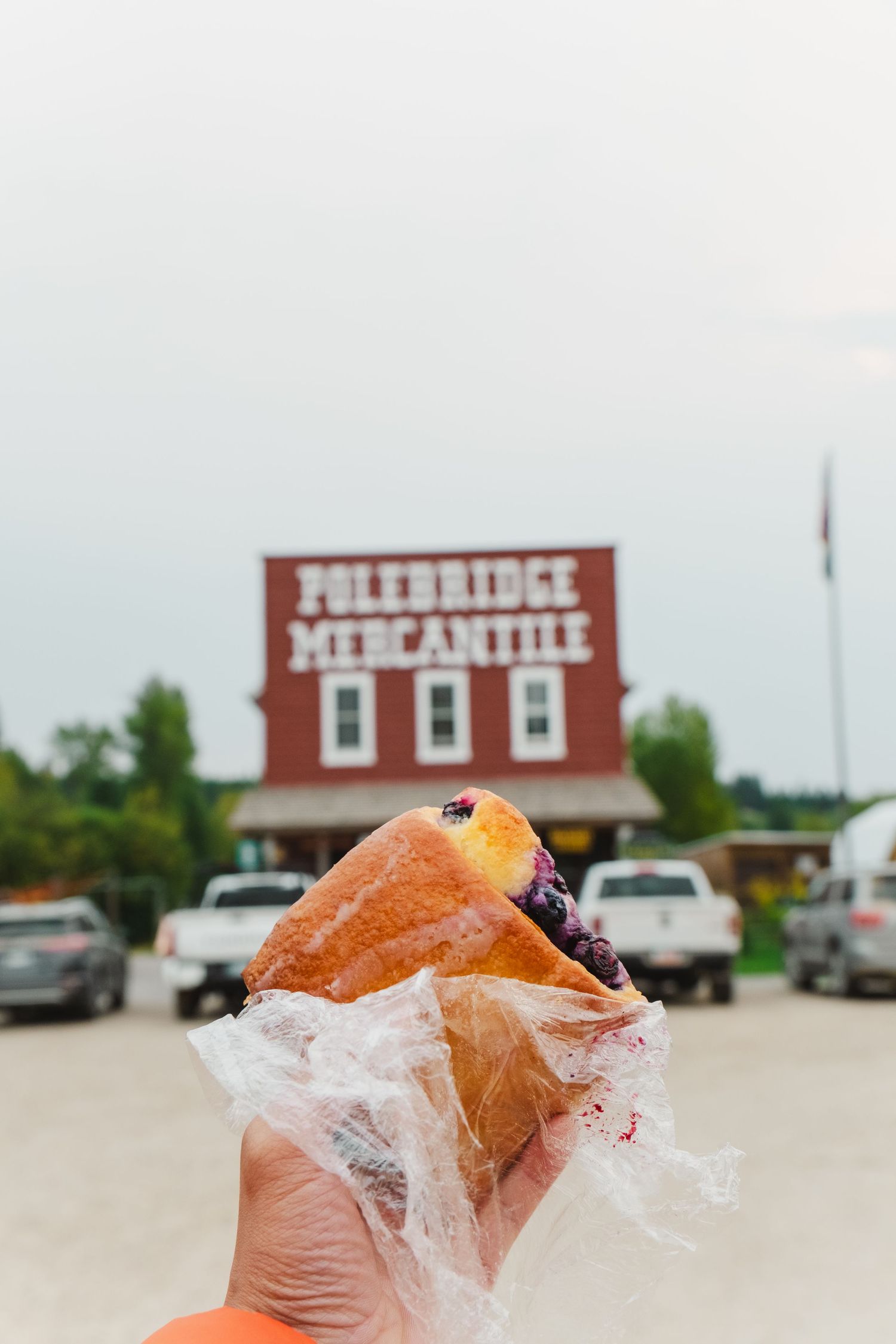 A series of photos showing a red rural store building and close-up shots of food being unwrapped from packaging.