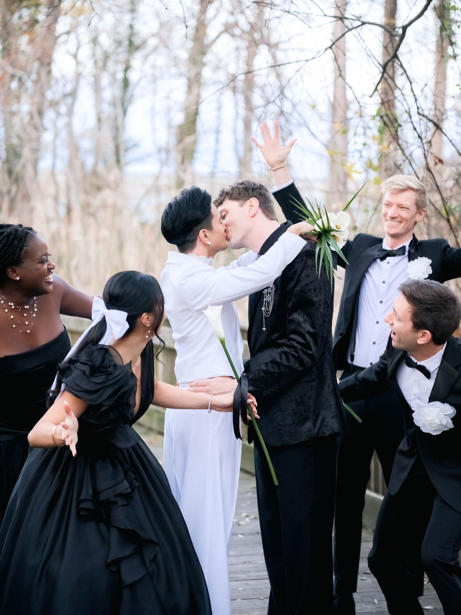 Five progressive photos show a joyful embrace between two people in formal black and white attire in a wooded setting.