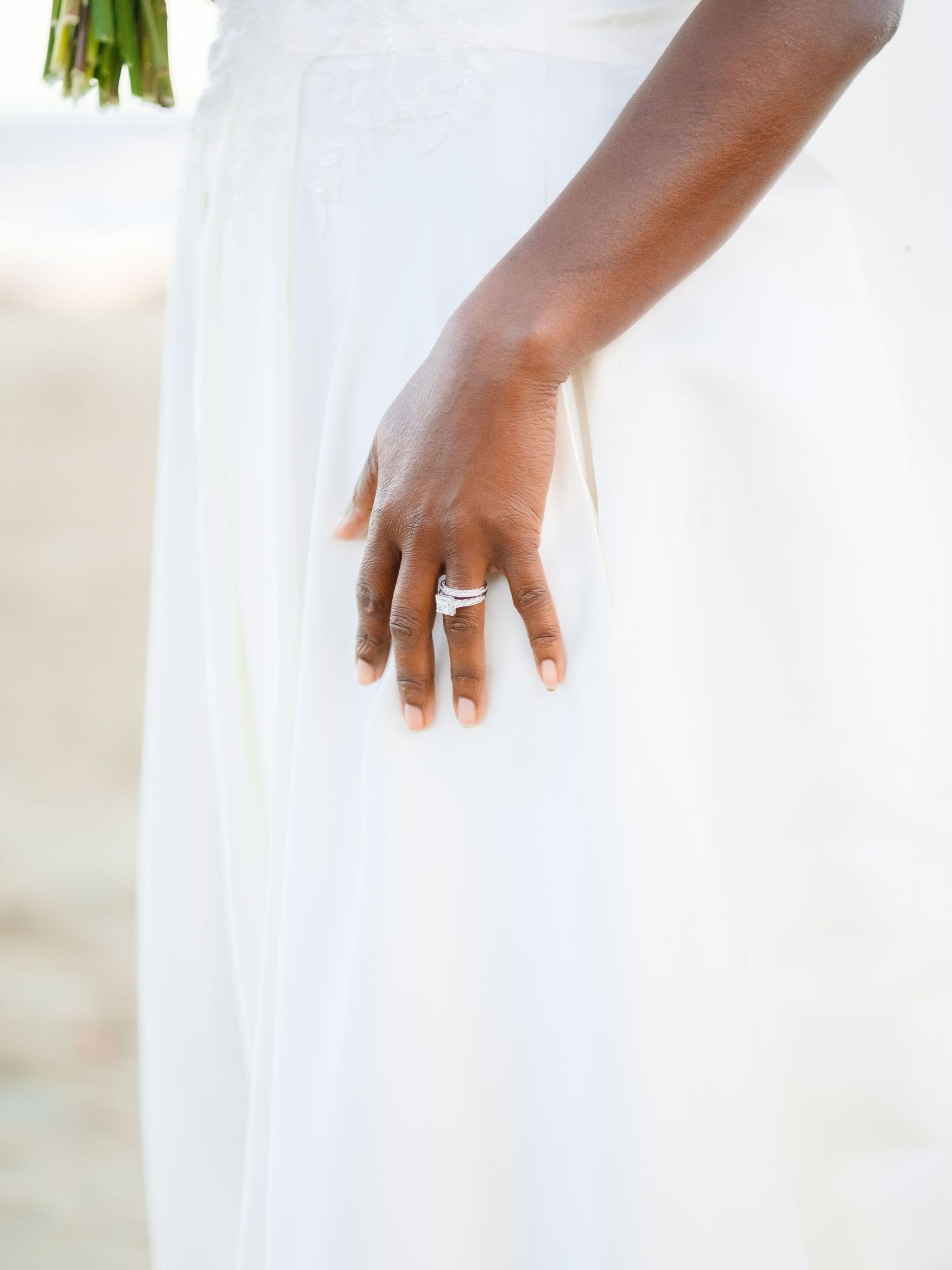 Close-up of hands wearing elegant wedding rings against a white background.