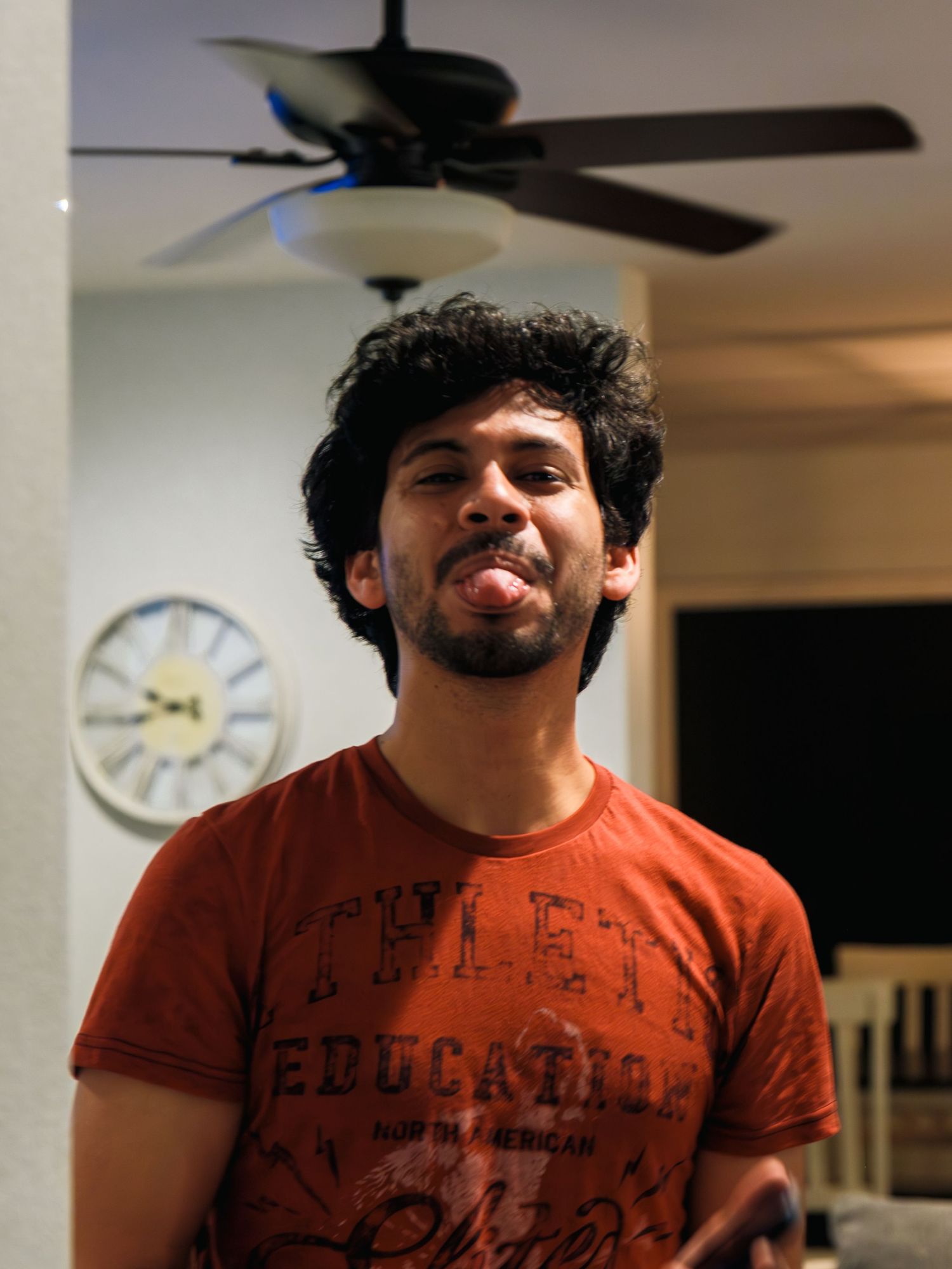 Person in a rust-colored t-shirt makes different facial expressions in a sequence of progressive photos.