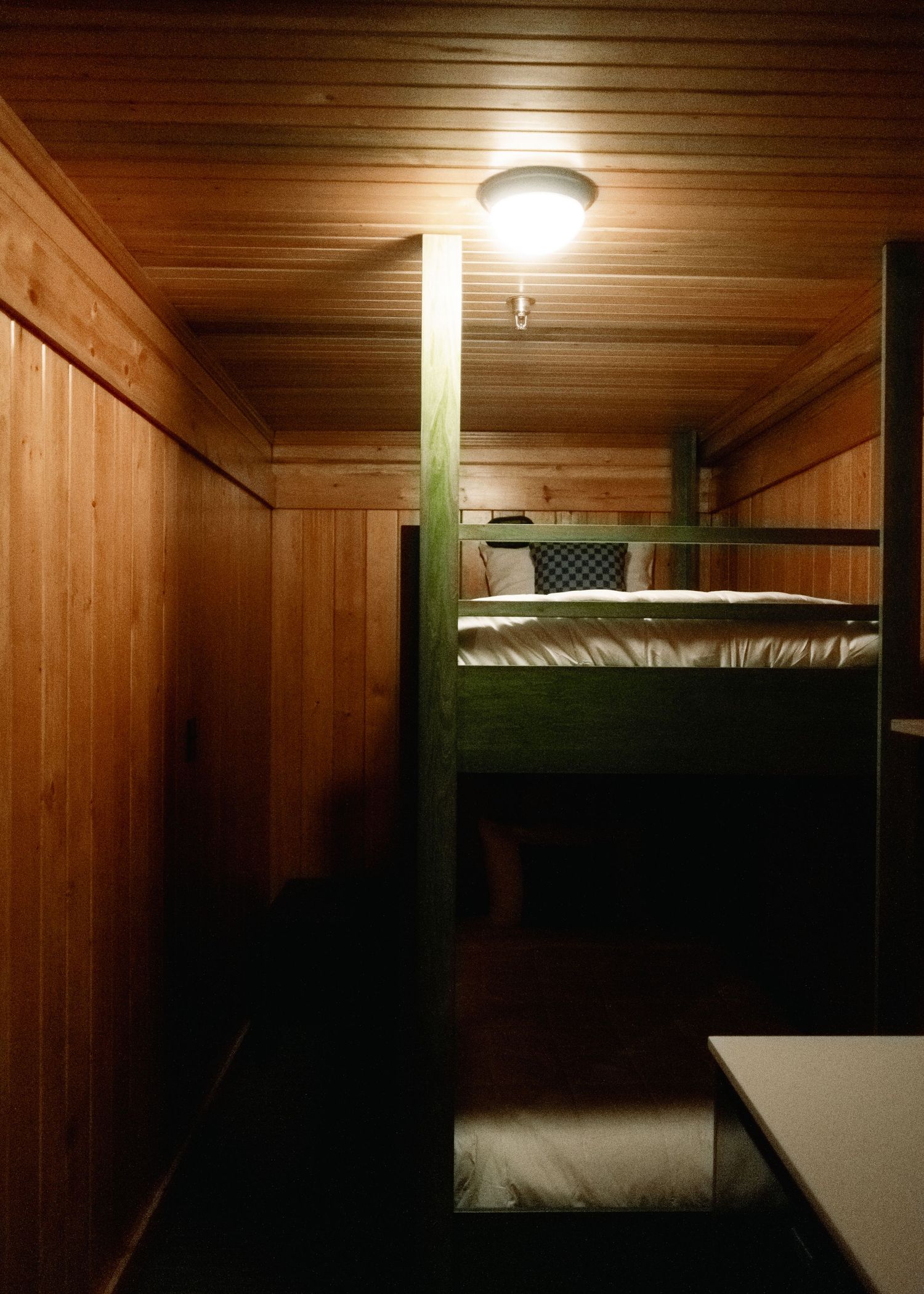 A series of five connected wooden lodge rooms with sloped ceilings and ceiling lights showing rustic interior architecture.