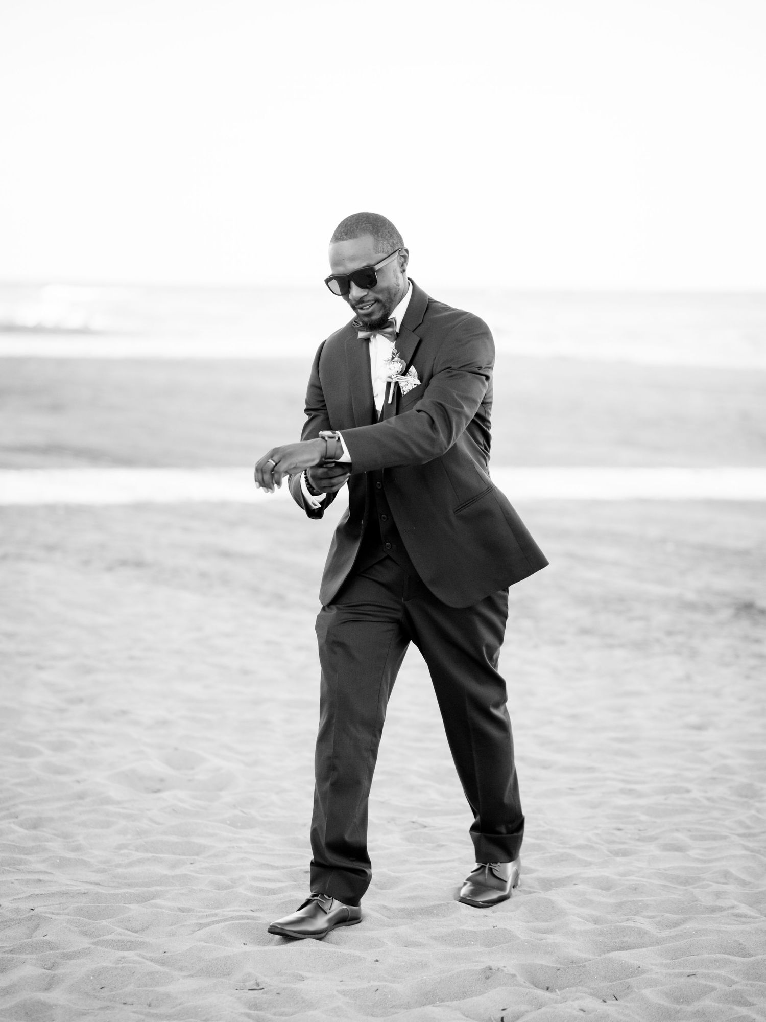 Candid moments captured of someone in formal attire playing in beach sand.