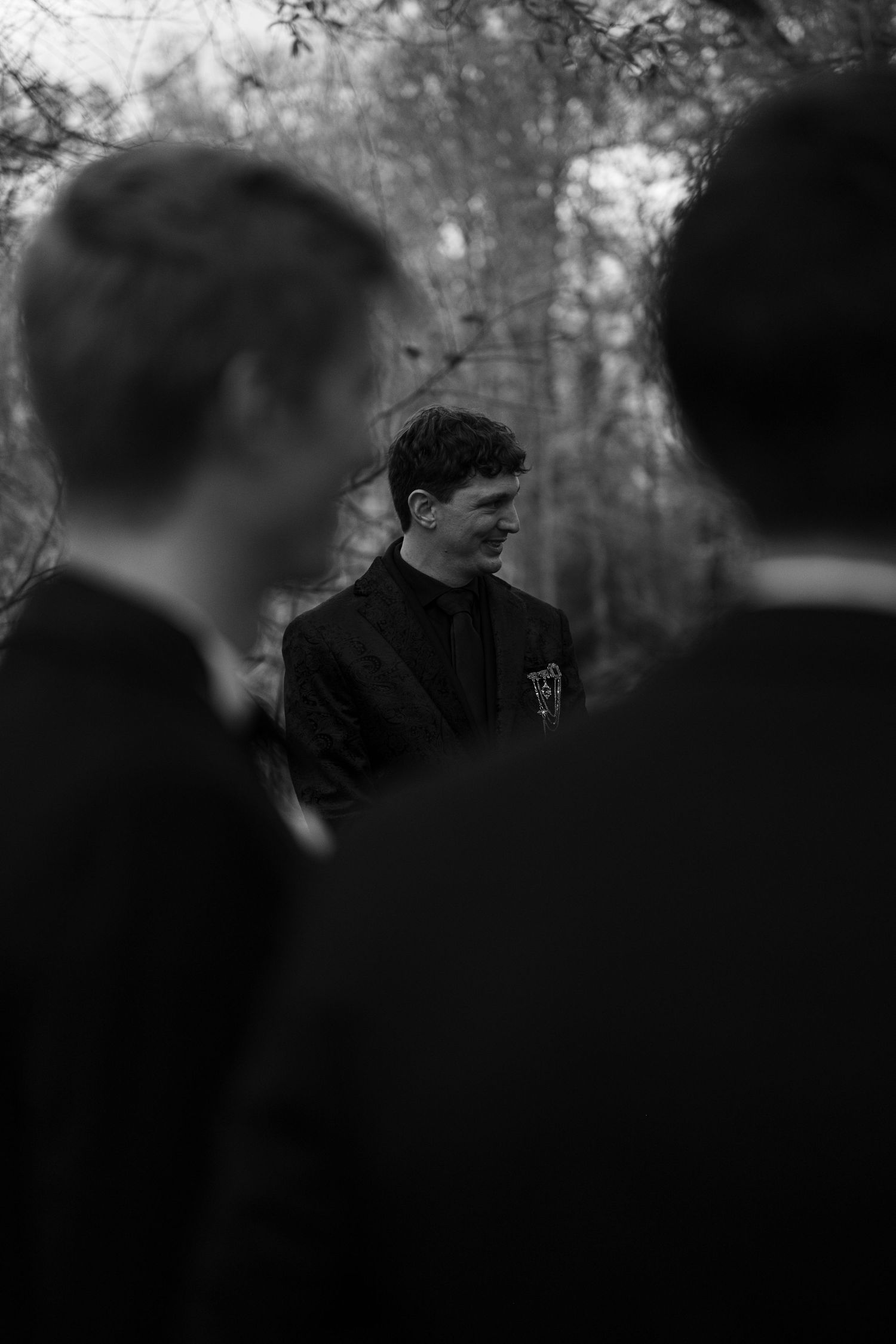 A dark, grainy sequence of monochrome photographs showing silhouettes of people standing together.