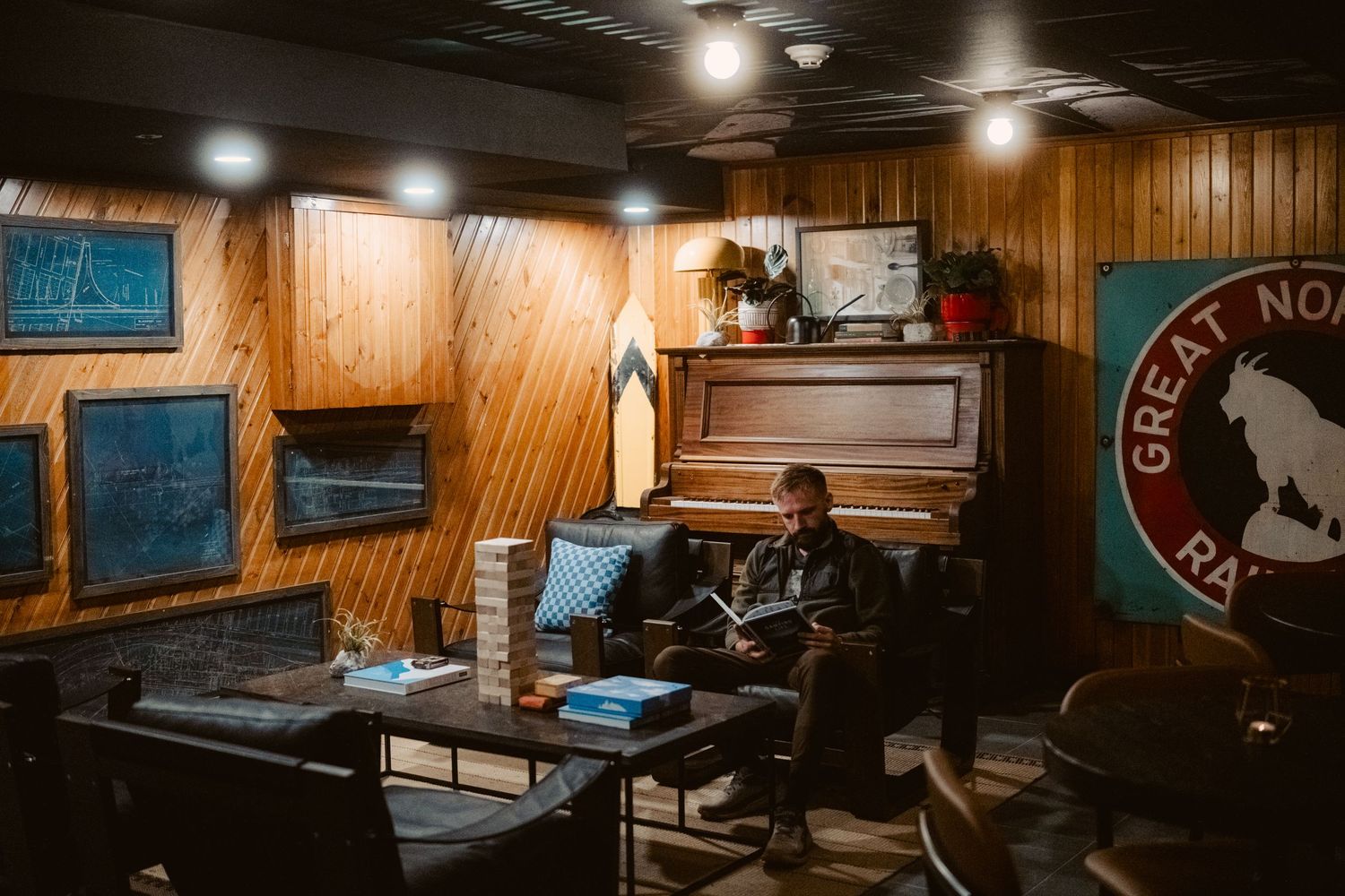 Rustic cafe interior with wood paneled walls, dim lighting, and vintage furnishings in a cozy seating area.