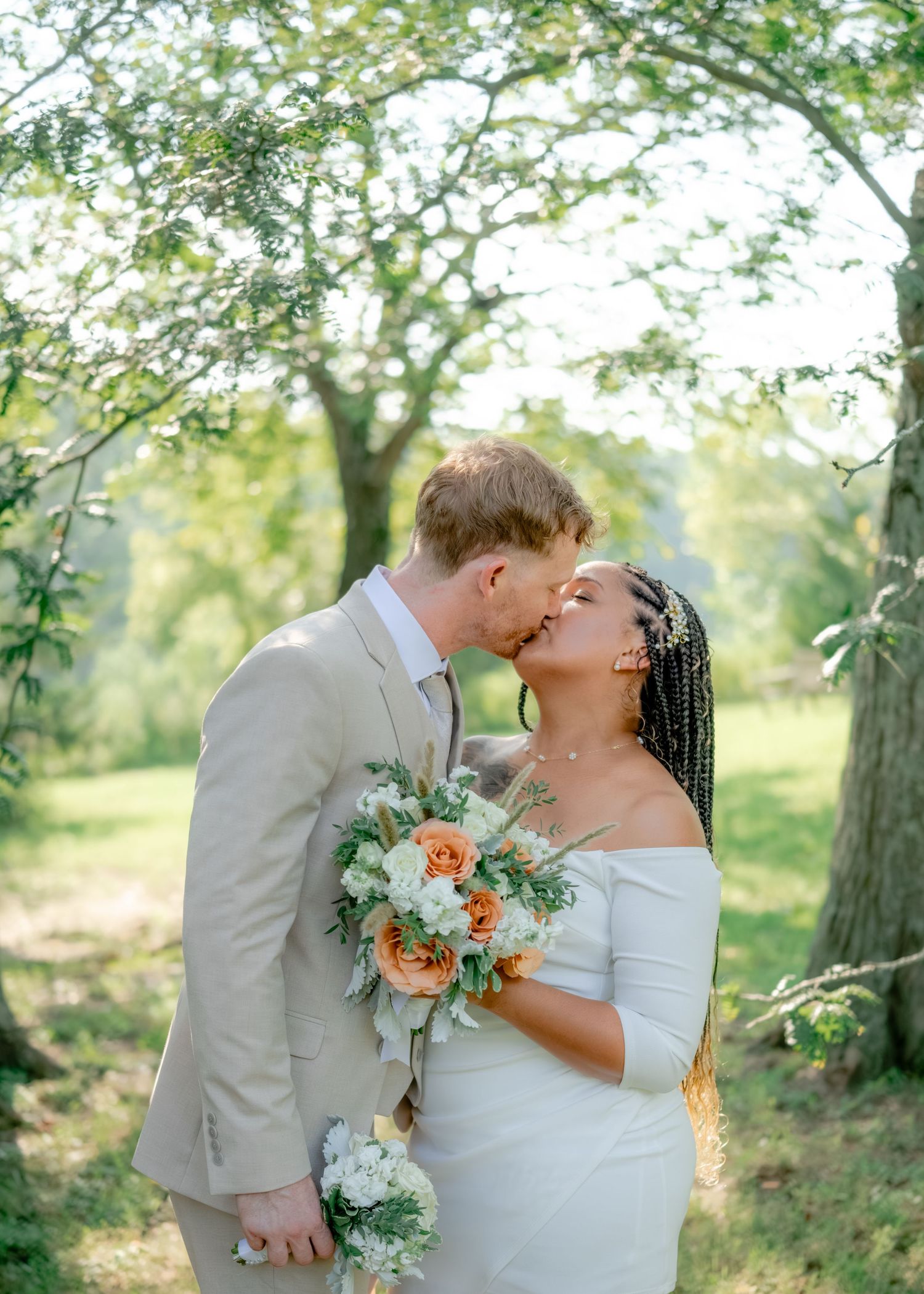 Romantic outdoor wedding photos show a couple in gray and white attire sharing intimate moments among trees on their special day.
