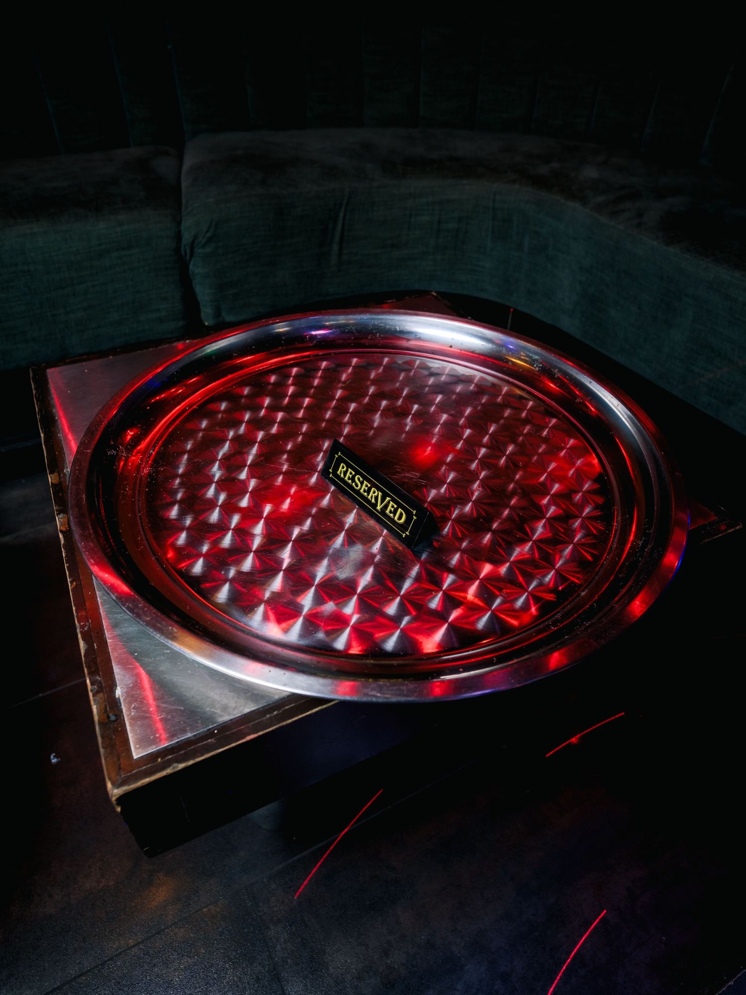 Close-up sequence showing red LED gaming keyboard illumination patterns with reflective shiny surface in dark environment.