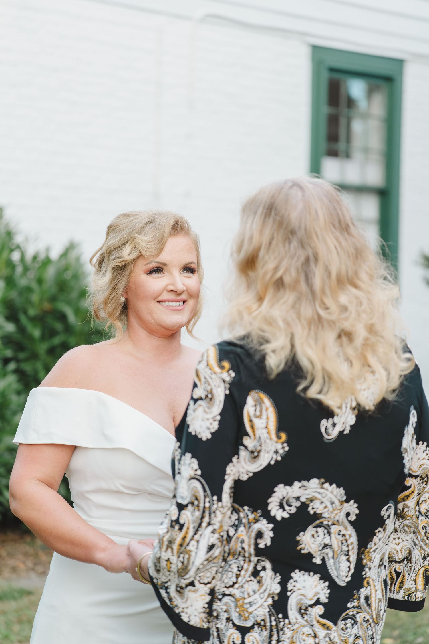 A heartwarming moment between two people showing the intricate embroidery details on a black formal dress.